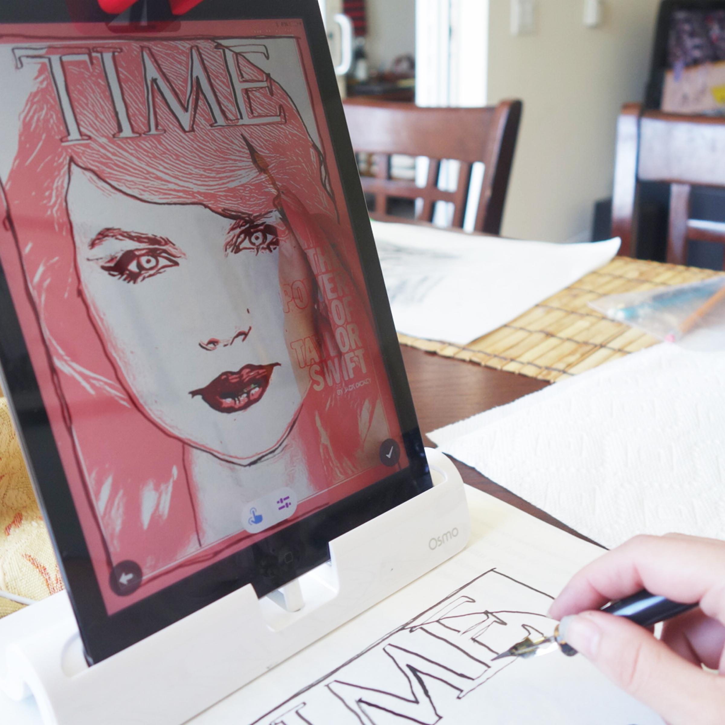 Osmo's Masterpiece app breaks down images into lines that the user can trace, watching their own hand move across the page on the screen. This picture shows the author copying a TIME cover featuring Taylor Swift. Notice the image of her hand and pen on the screen.