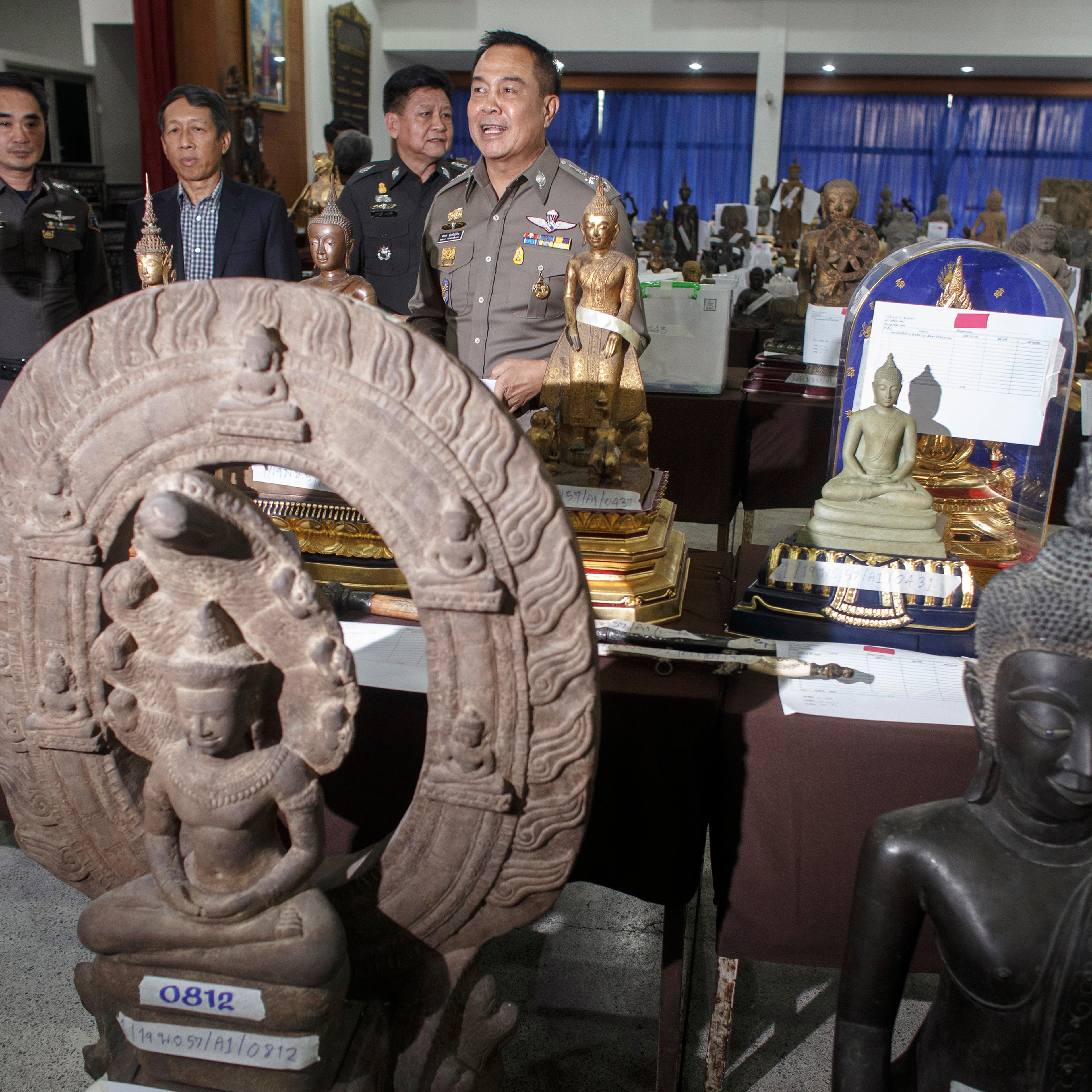 Poompanmuang, chief of Royal Thai Police, stands among antique Buddha statues that were seized during an investigation into Chayaphan, a former commissioner of the Central Investigation Bureau, at a military base in Bangkok