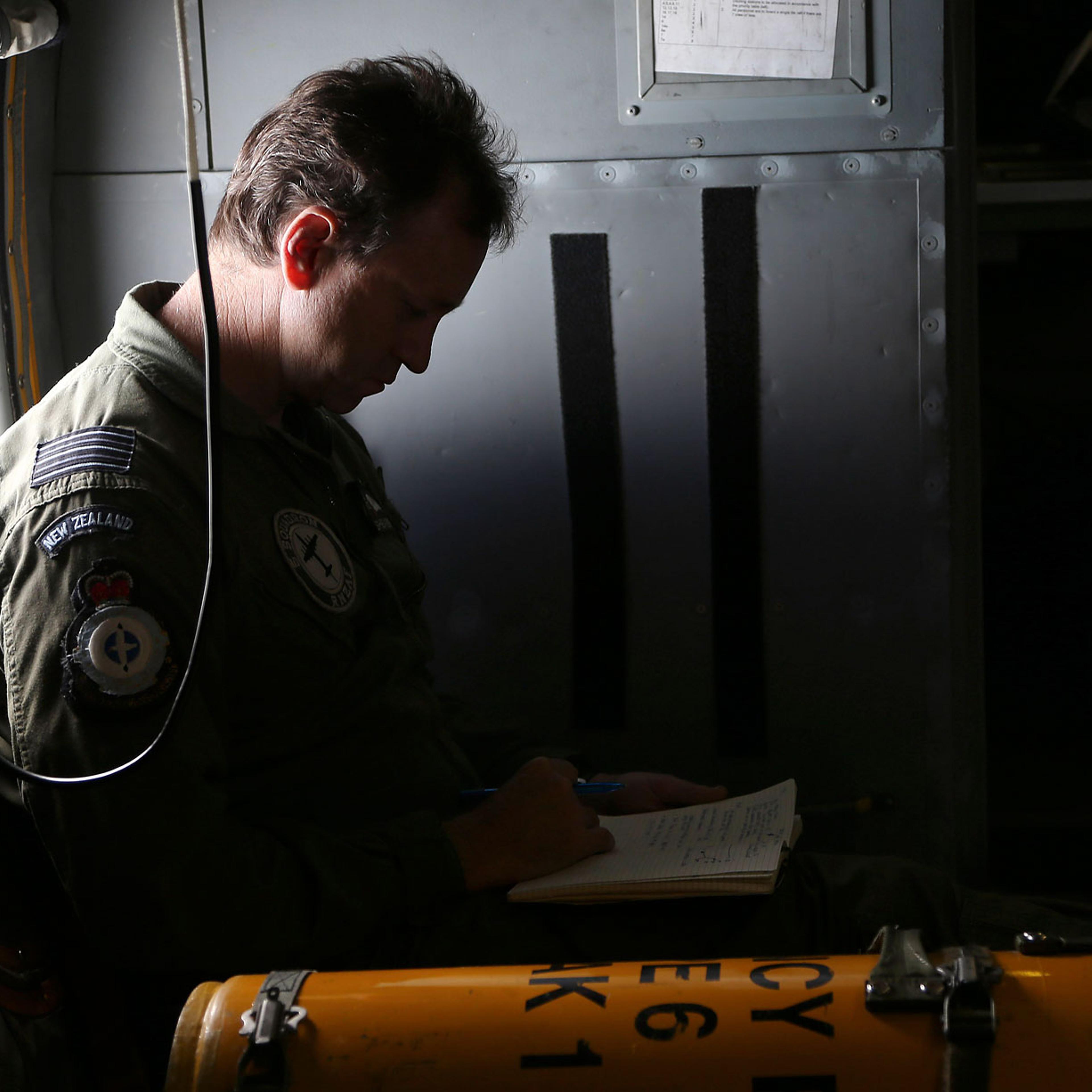 Wing commander Rob Shearer, captain of the Royal New Zealand Air Force P3 Orion, reads through his notes before reaching the search area for missing Malaysia Airlines Flight MH370 in the southern Indian Ocean, near the coast of Western Australia