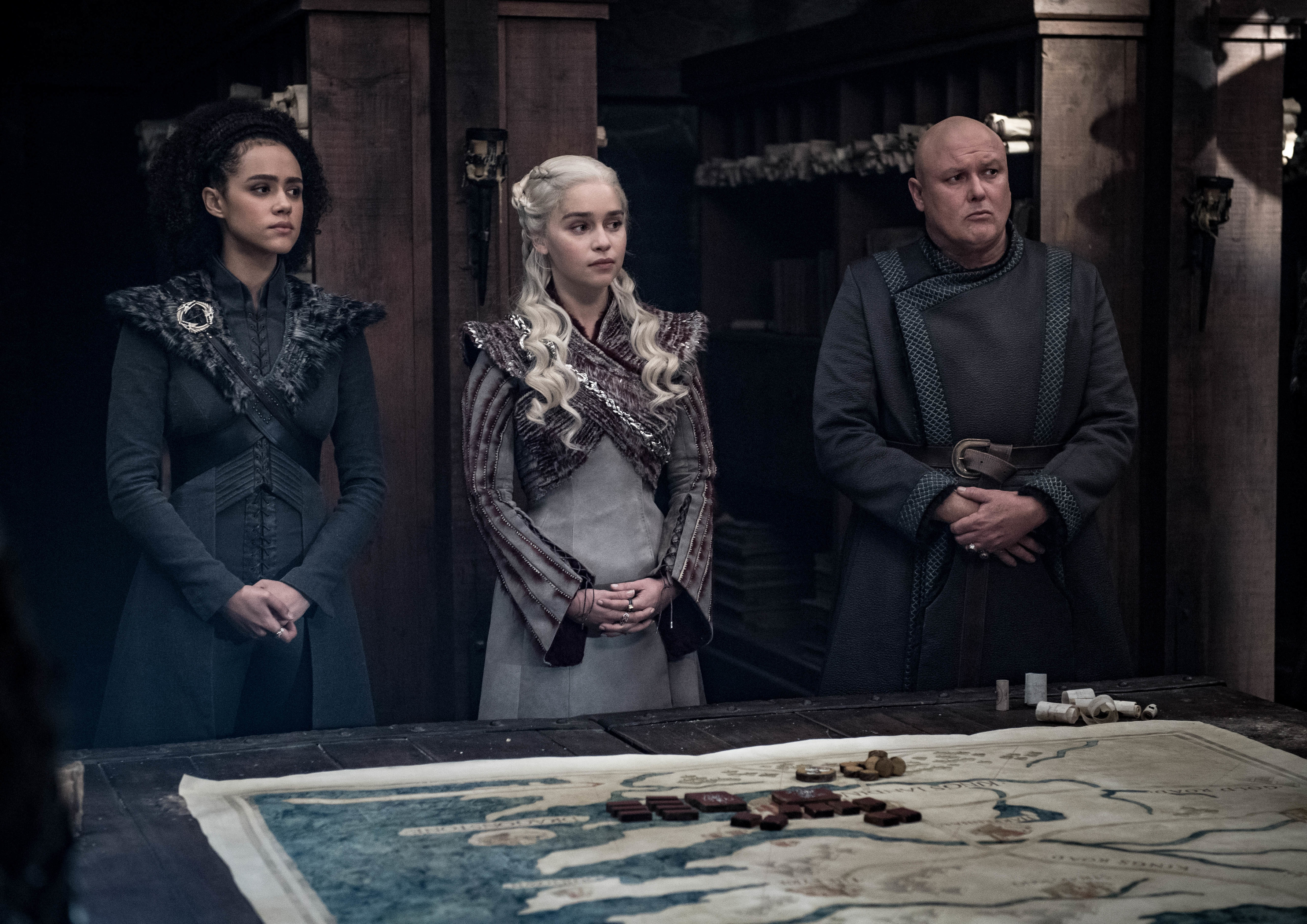 Nathalie Emmanuel as Missandei, Emilia Clarke as Daenerys Targaryen, and Conleth Hill as Varys.