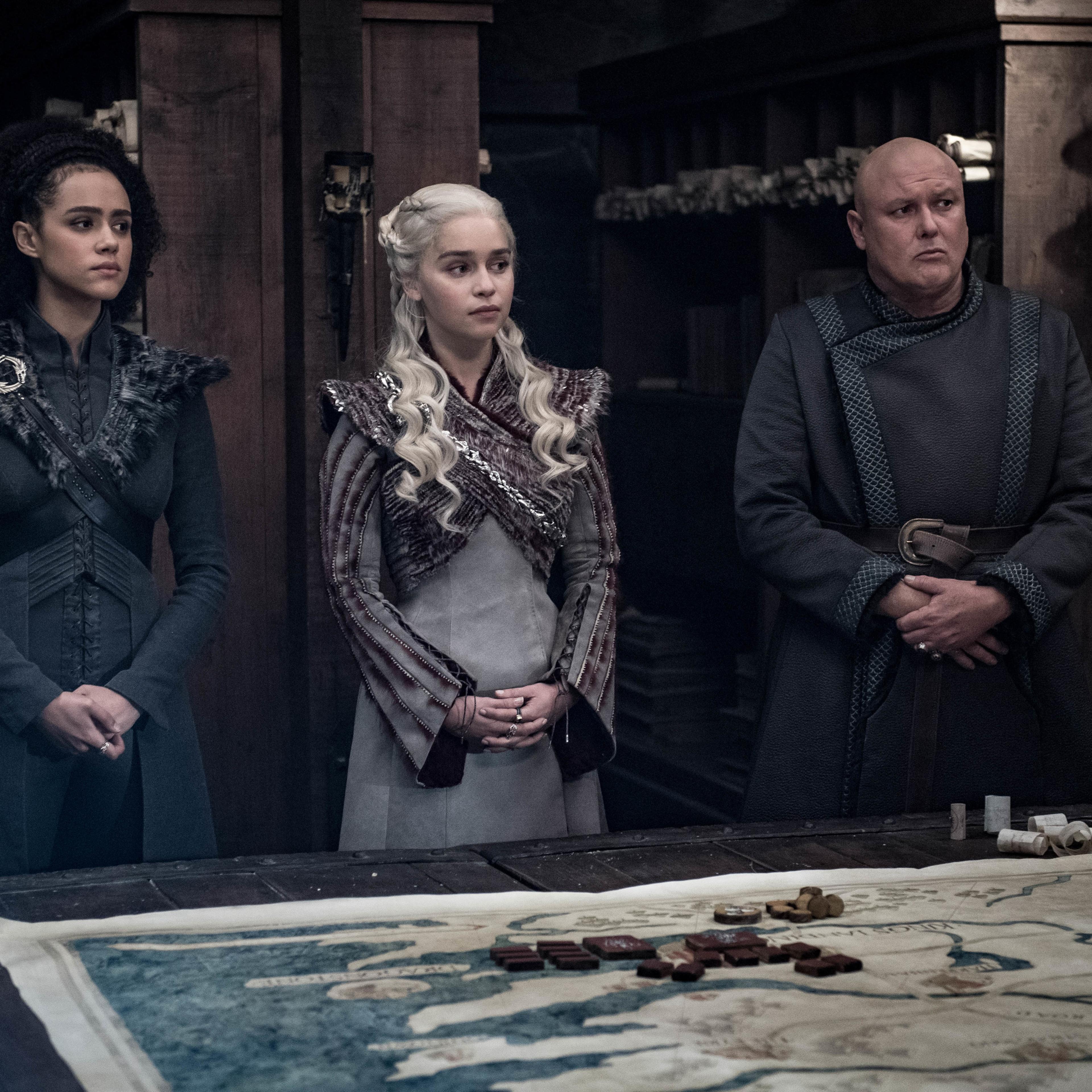 Nathalie Emmanuel as Missandei, Emilia Clarke as Daenerys Targaryen, and Conleth Hill as Varys.