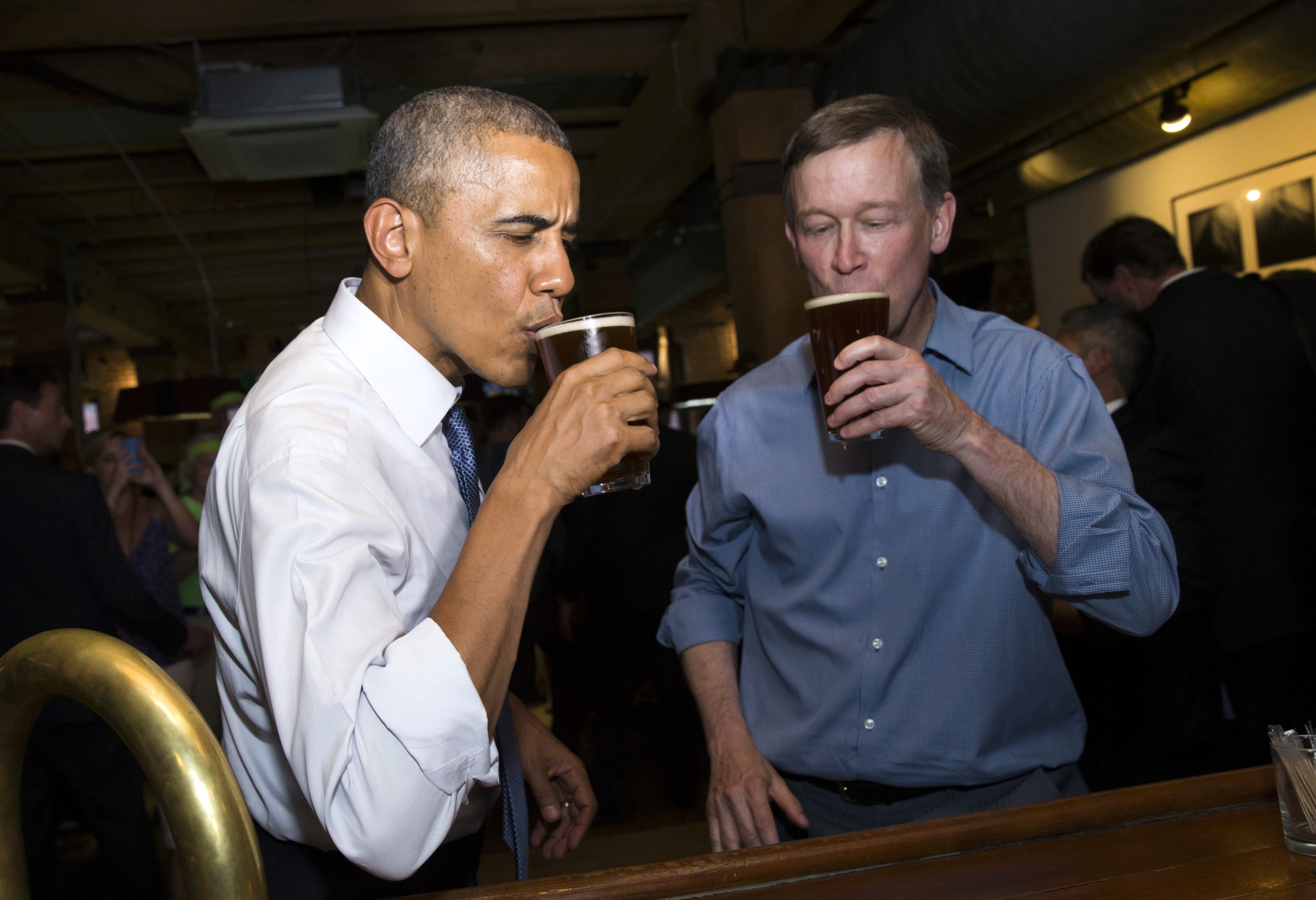 U.S. President Barack Obama enjoys a beer with Colorado Governor John Hickenlooper during a stop in a bar in Denver on July 8, 2014.