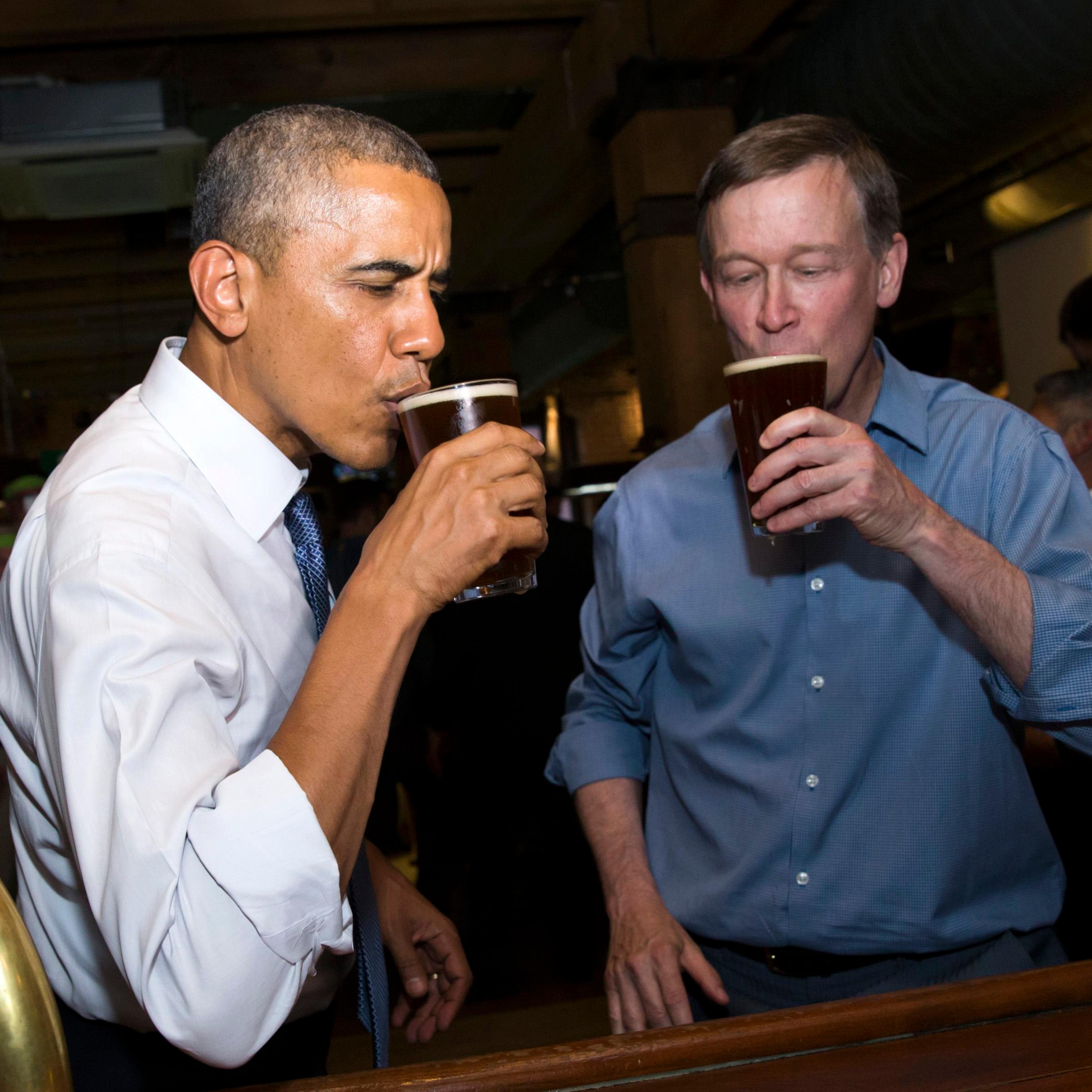 U.S. President Barack Obama enjoys a beer with Colorado Governor John Hickenlooper during a stop in a bar in Denver on July 8, 2014.