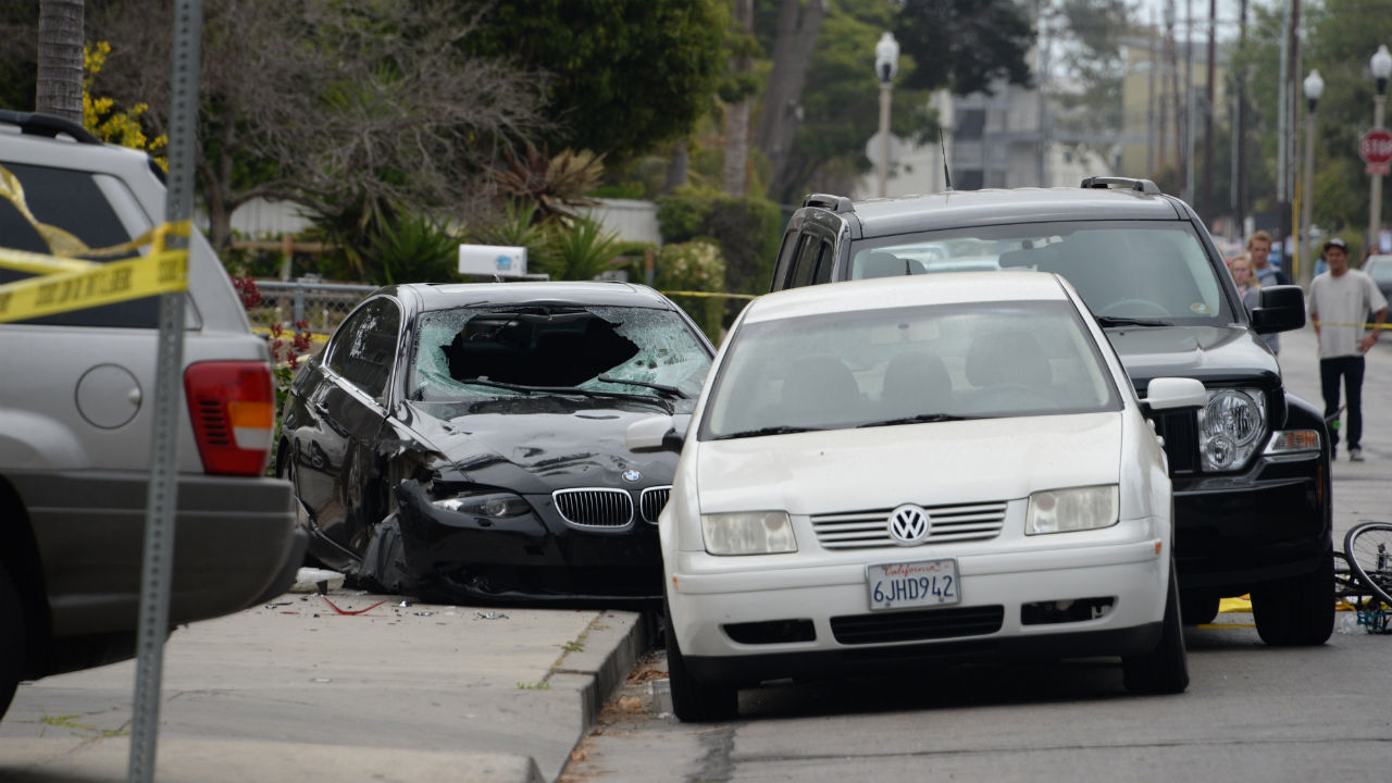 A crashed car (-L), allegedly driven by a gunman, sits partly on the sidewalk on May 24, 2014 in Isla Vista, California.