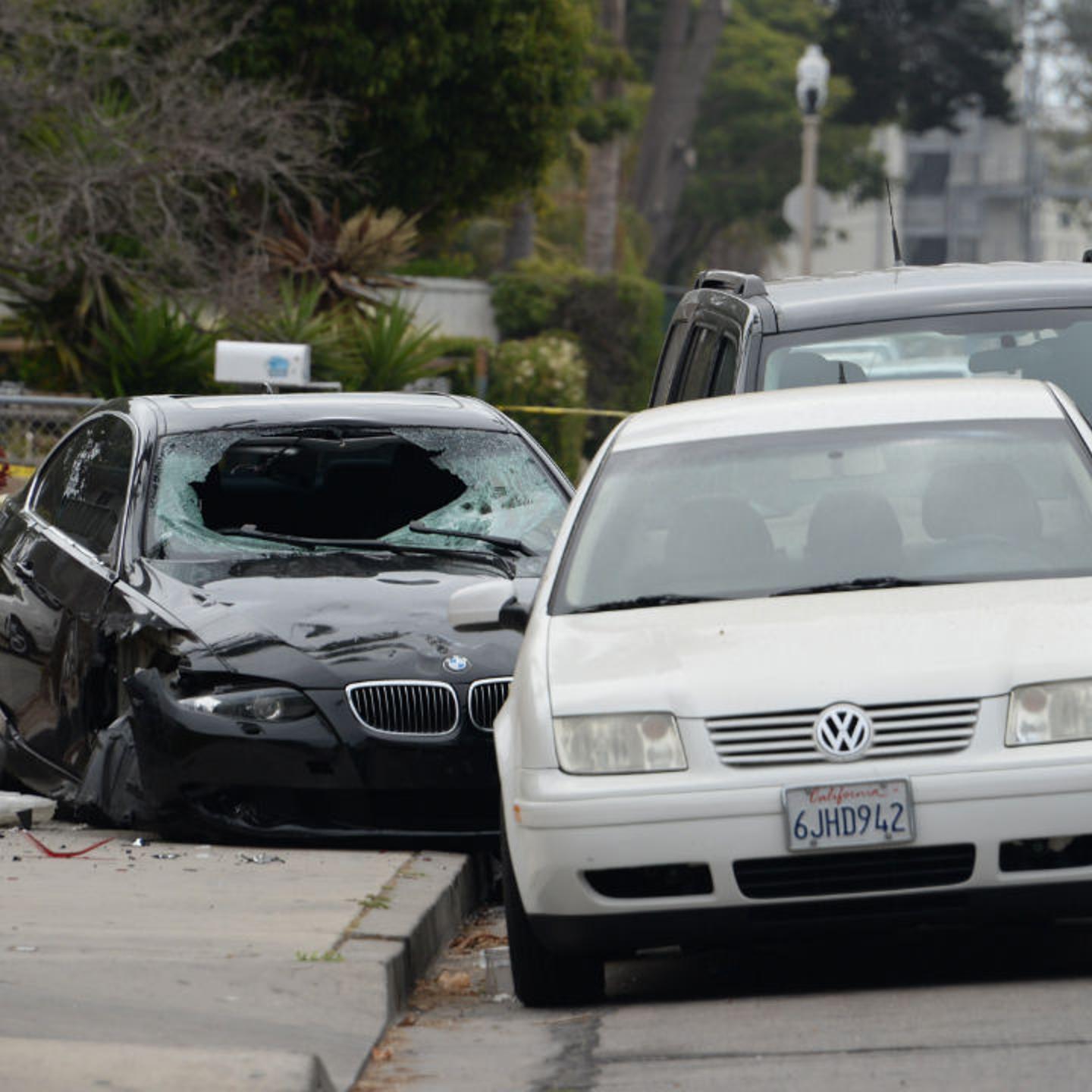 A crashed car (-L), allegedly driven by a gunman, sits partly on the sidewalk on May 24, 2014 in Isla Vista, California.