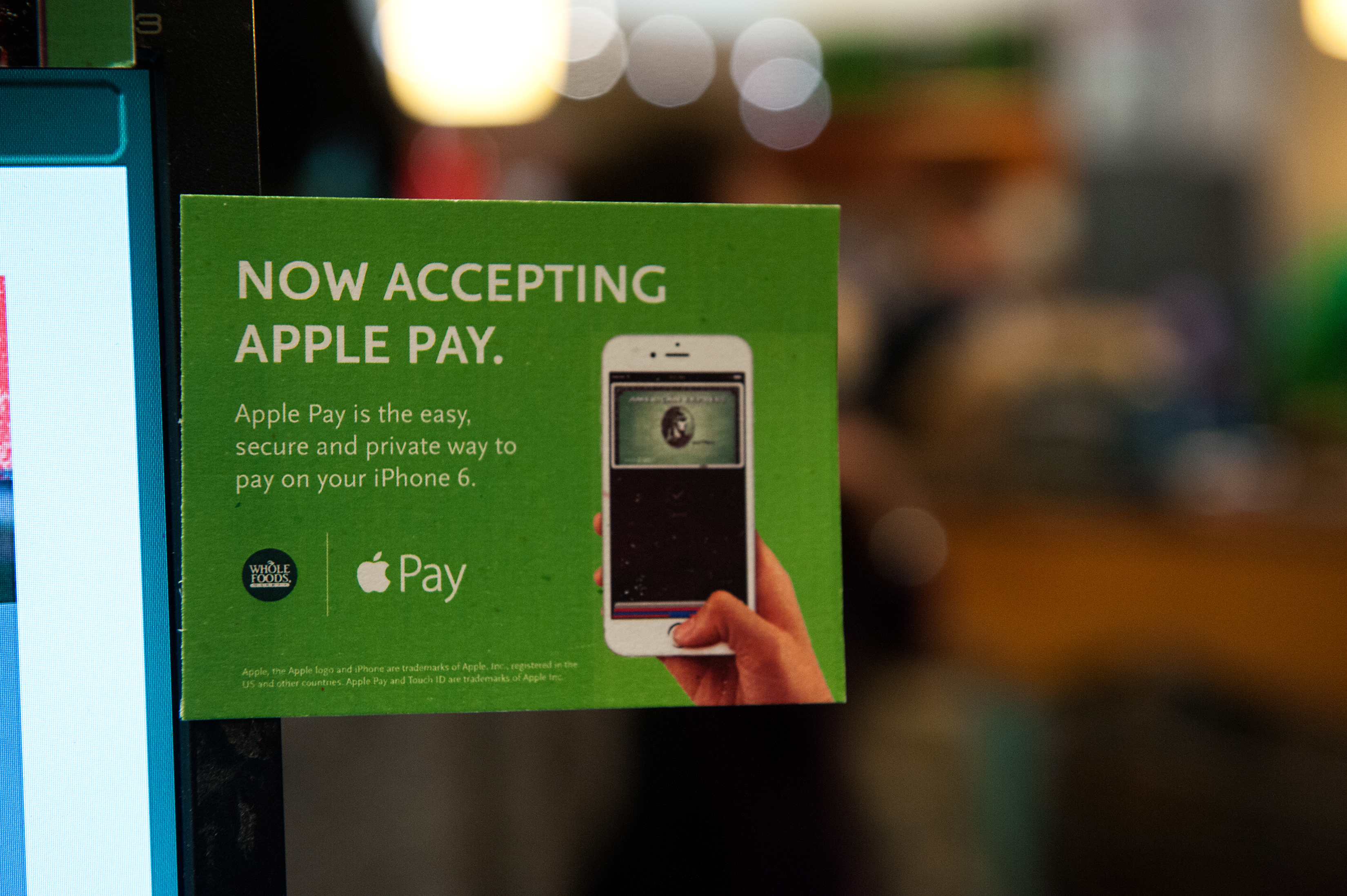 Apple Pay is promoted on signs placed at the cash register of Whole Foods in Columbus Circle on October 20, 2014 in New York City.