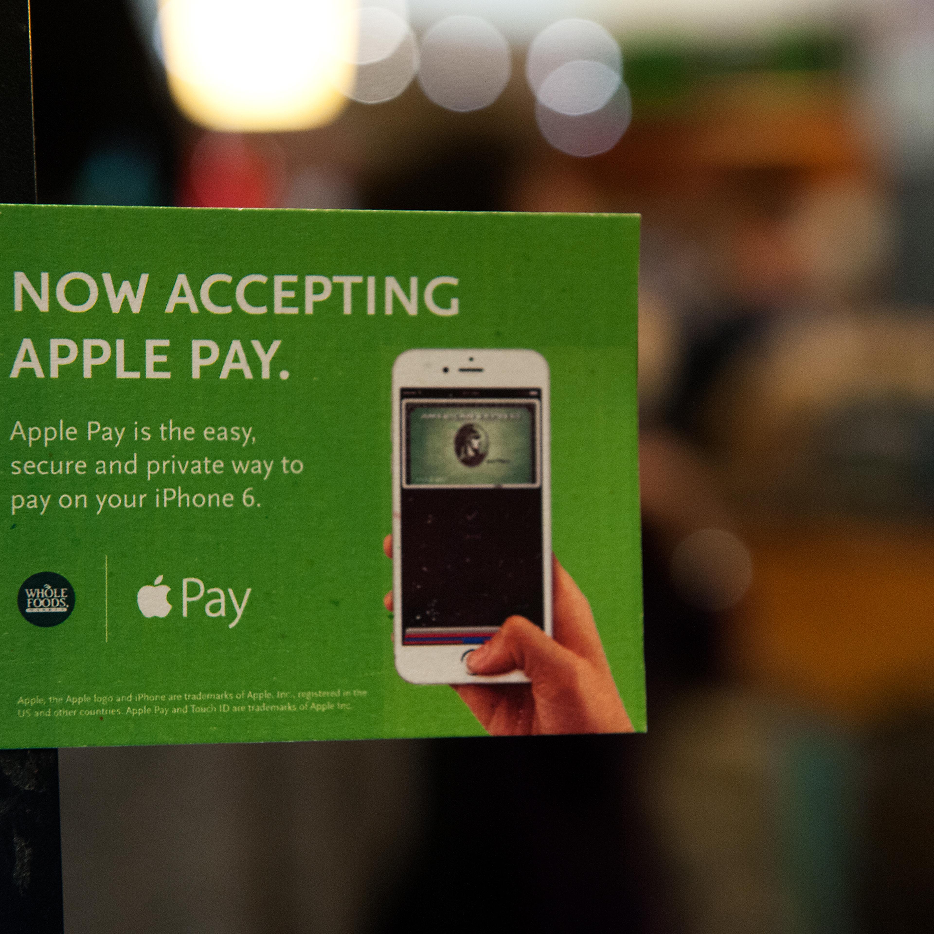 Apple Pay is promoted on signs placed at the cash register of Whole Foods in Columbus Circle on October 20, 2014 in New York City.
