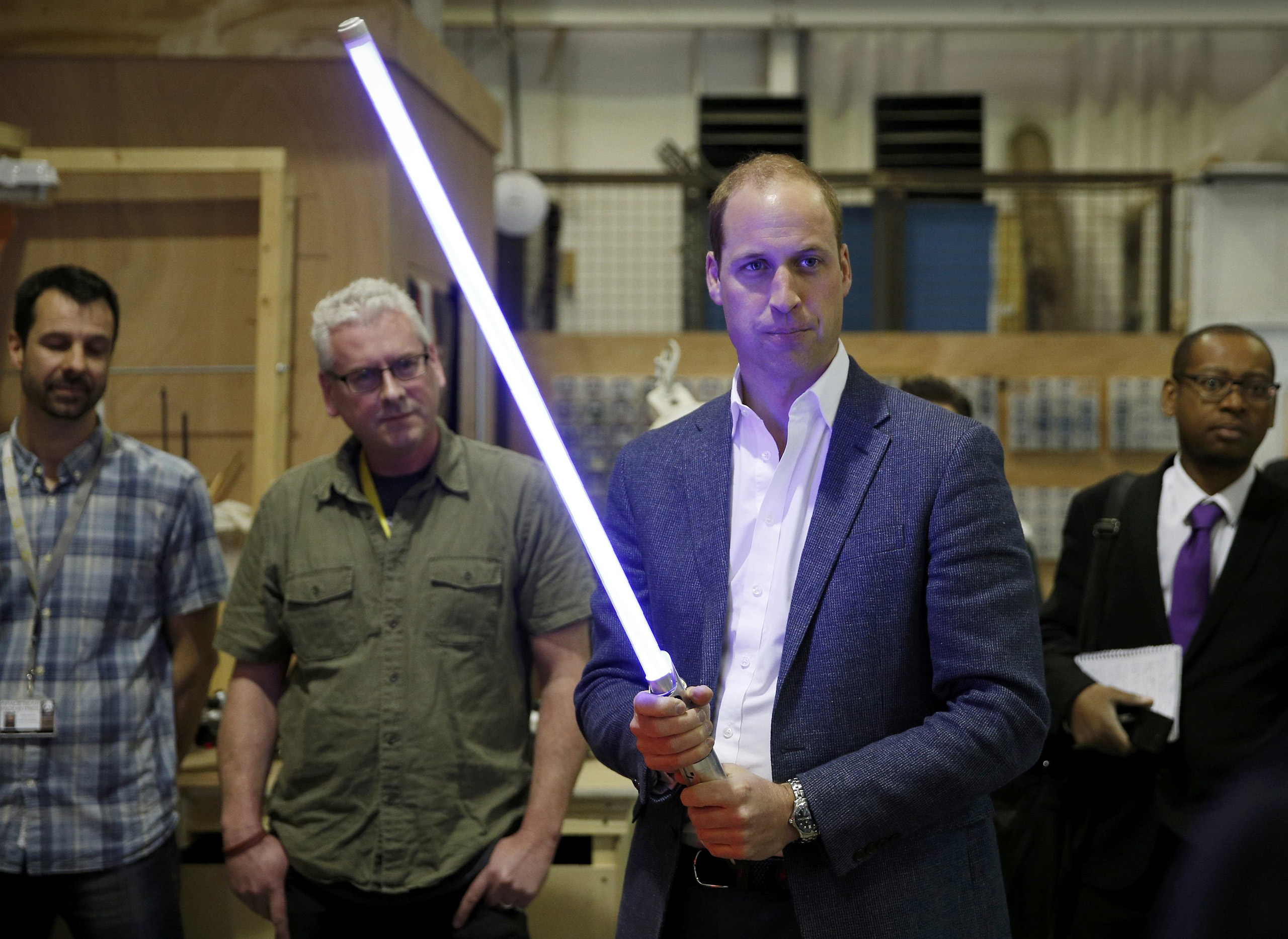 Britain's Prince William holds a light saber during a visit to the Star Wars film set at Pinewood Studios near Iver Heath, west of London, April 19, 2016.