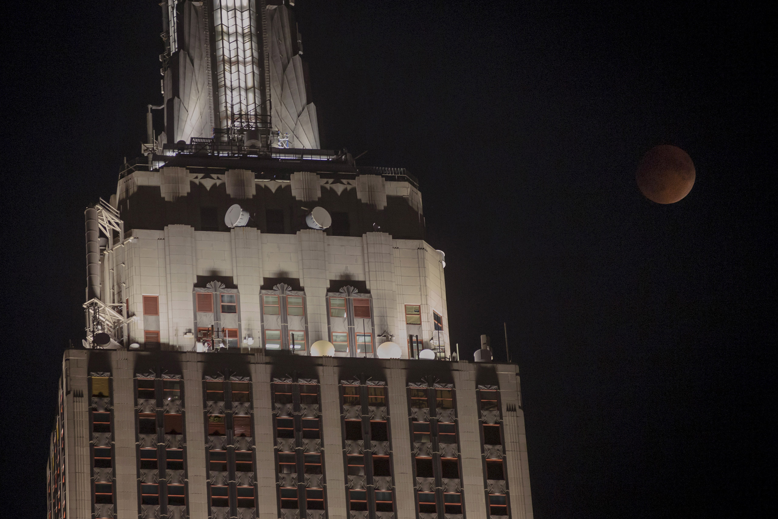 A supermoon is seen rising beside the Empire State Building in Manhattan, New York September 27, 2015. Sky-watchers around the world are in for a treat Sunday night and Monday when the shadow of Earth casts a reddish glow on the moon, the result of rare 