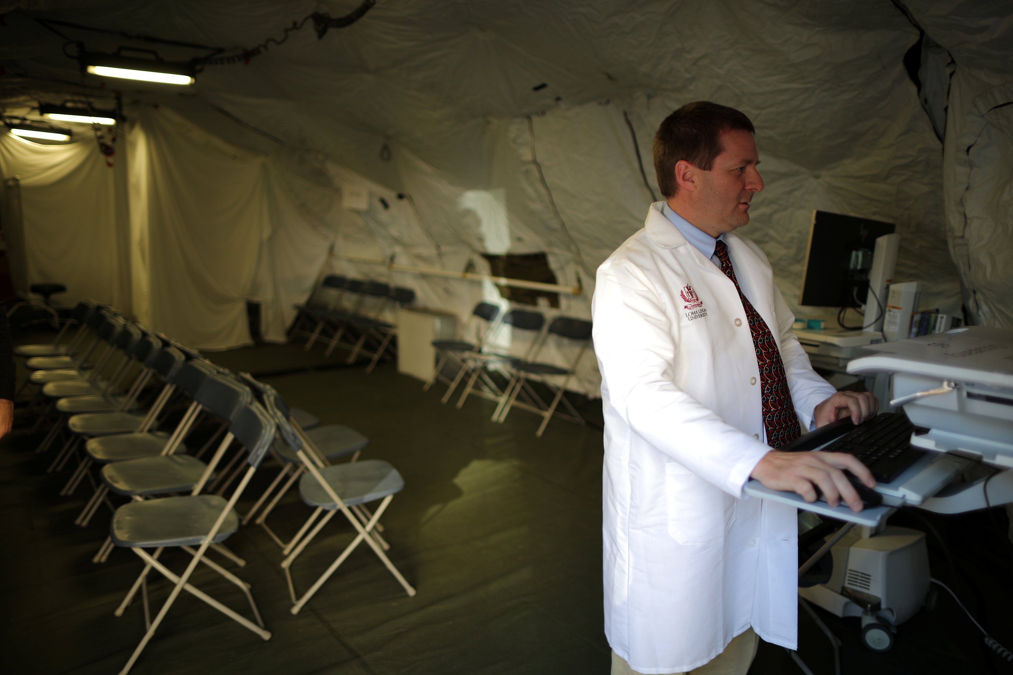 Dr Adrian Cotton stands inside a triage surge tent at Loma Linda University Health Center for patients infected with an influenza A strain known as H3N2, in Loma Linda