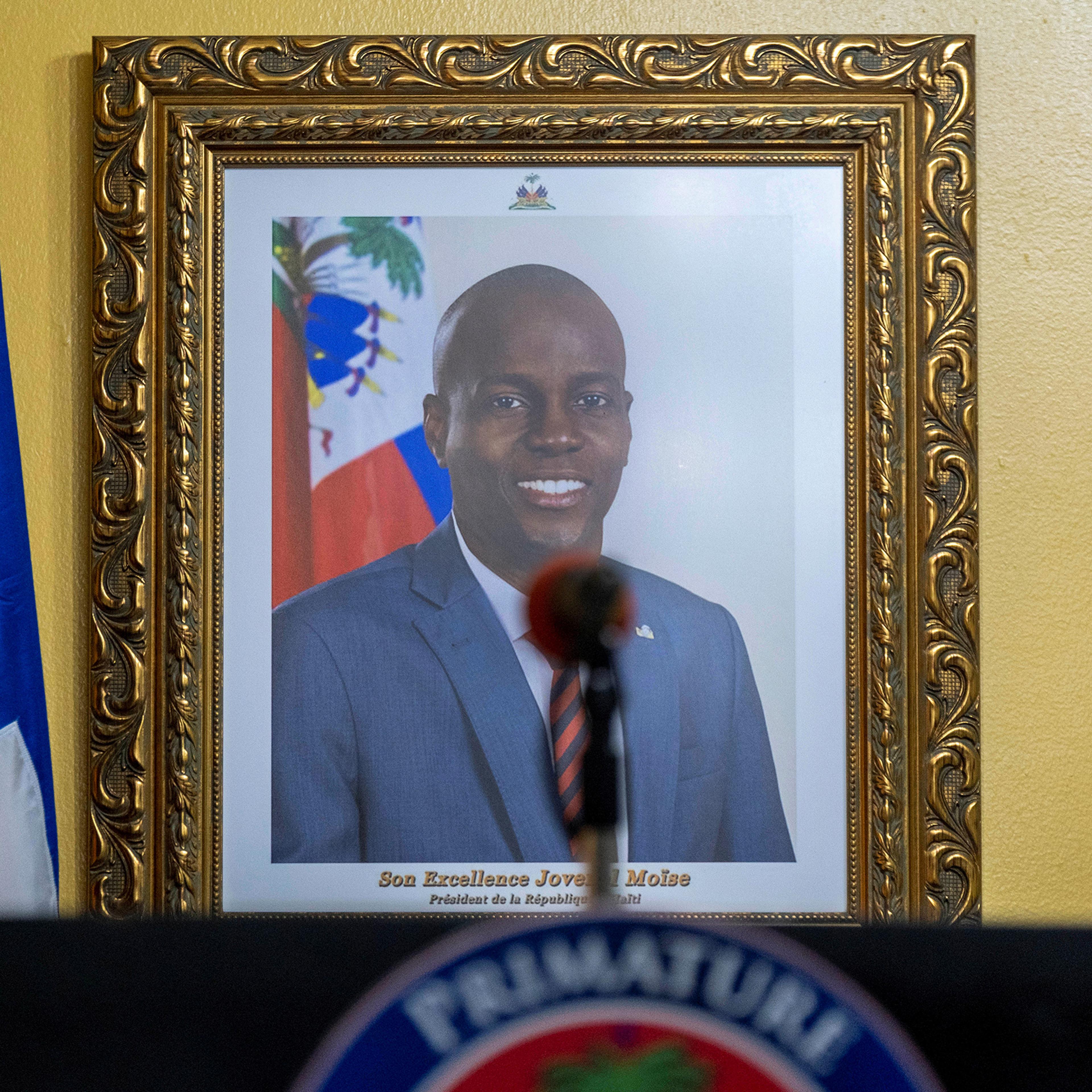 A picture of the late Haitian President Jovenel Moise hangs on a wall before a news conference