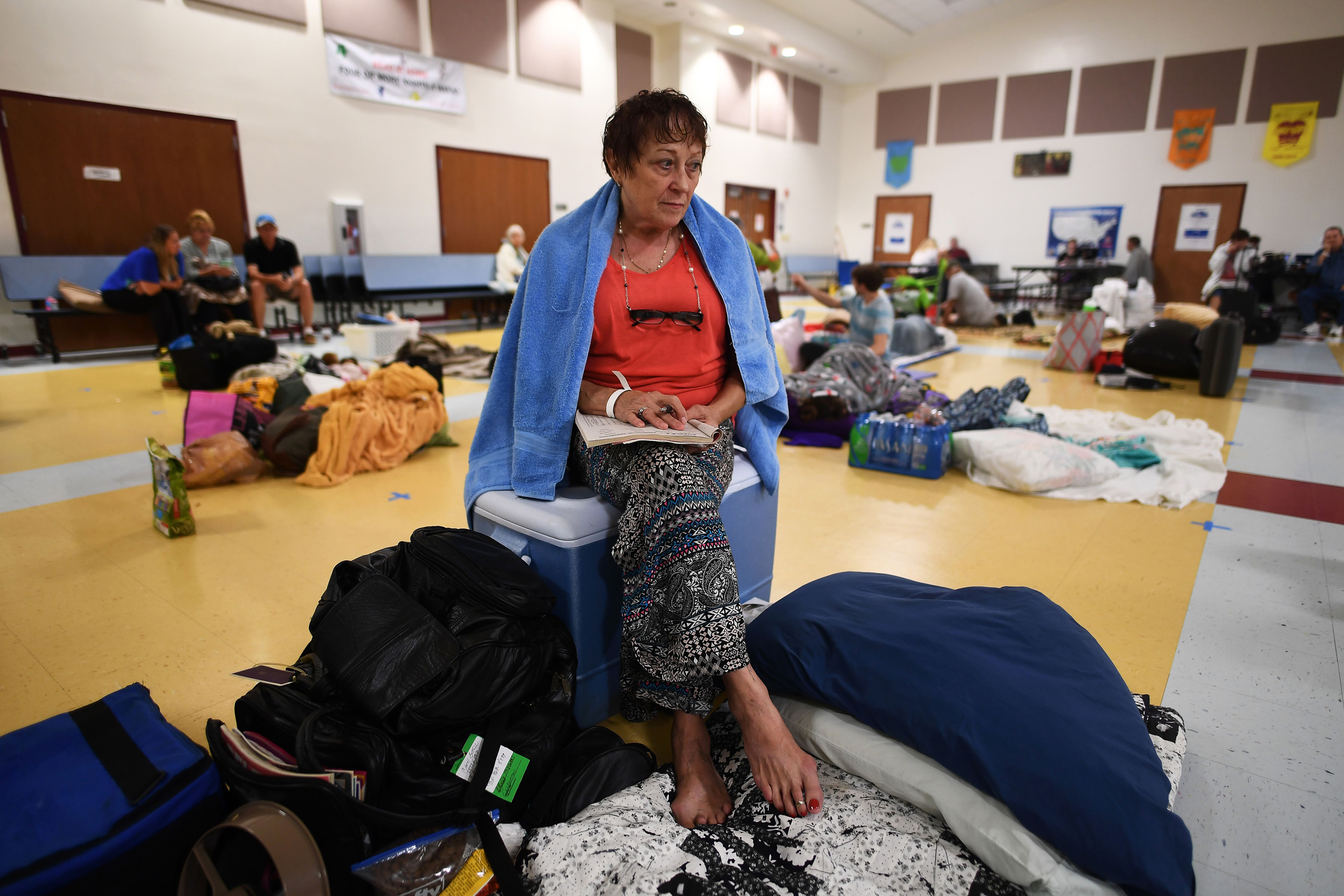 Carol Bettelli sits along with others in a makeshift shelter at the Timberlin Creek Elementary School in St. Augustine, Florida, on October 6, 2016, ahead of hurricane Matthew. Some 1.5 million people are under evacuation orders in Florida in preparation