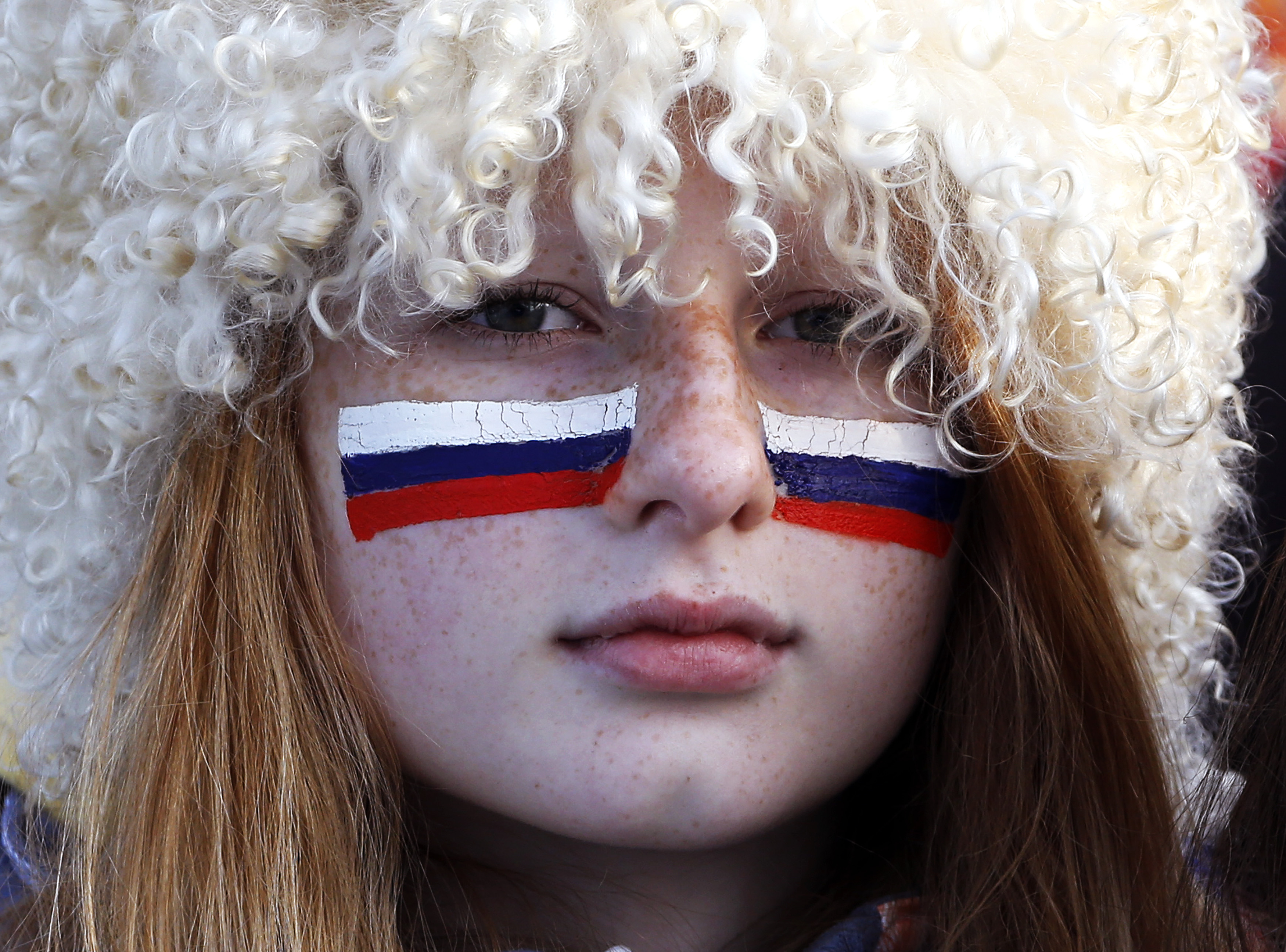 A Russian fan with her face painted with the Russian flag watches the men's quarter-finals ice hockey game between Russia and Finland. Russia was eliminated from the men's ice hockey competition at the Sochi Games on Wednesday following a 3-1 quarter-fin
