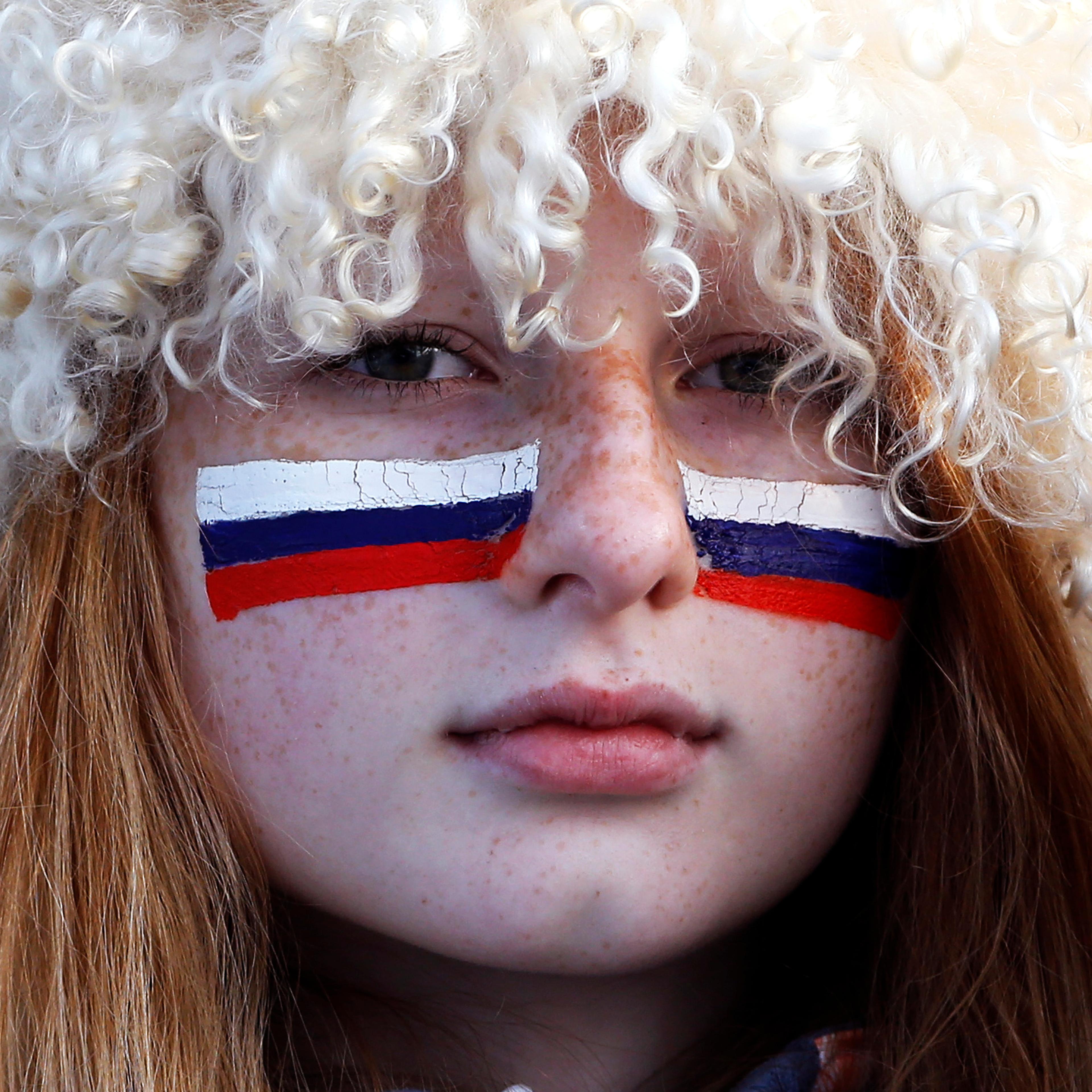 A Russian fan with her face painted with the Russian flag watches the men's quarter-finals ice hockey game between Russia and Finland. Russia was eliminated from the men's ice hockey competition at the Sochi Games on Wednesday following a 3-1 quarter-fin