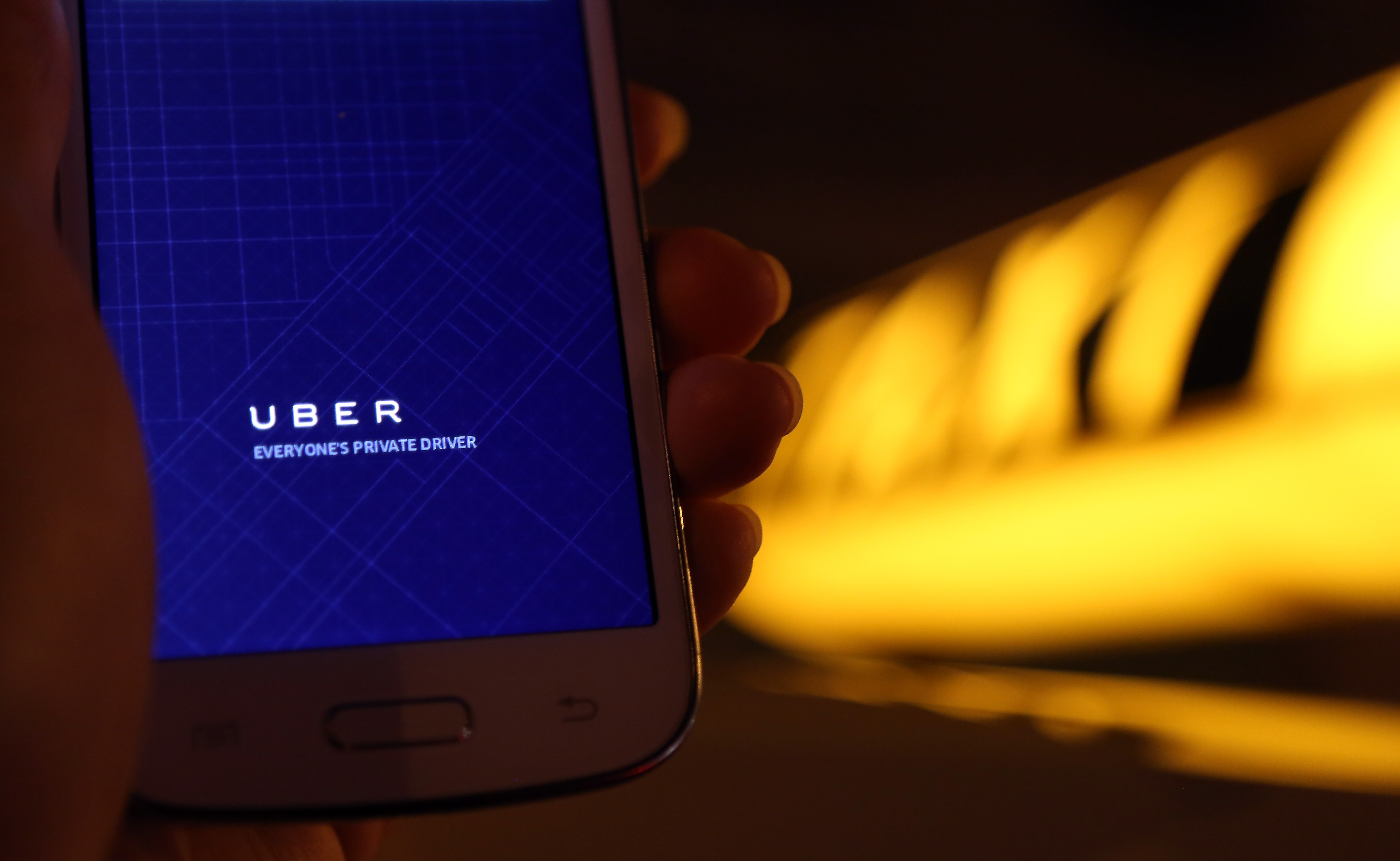 A woman uses the Uber app on an Samsung smartphone on September 2, 2014 in Berlin, Germany.