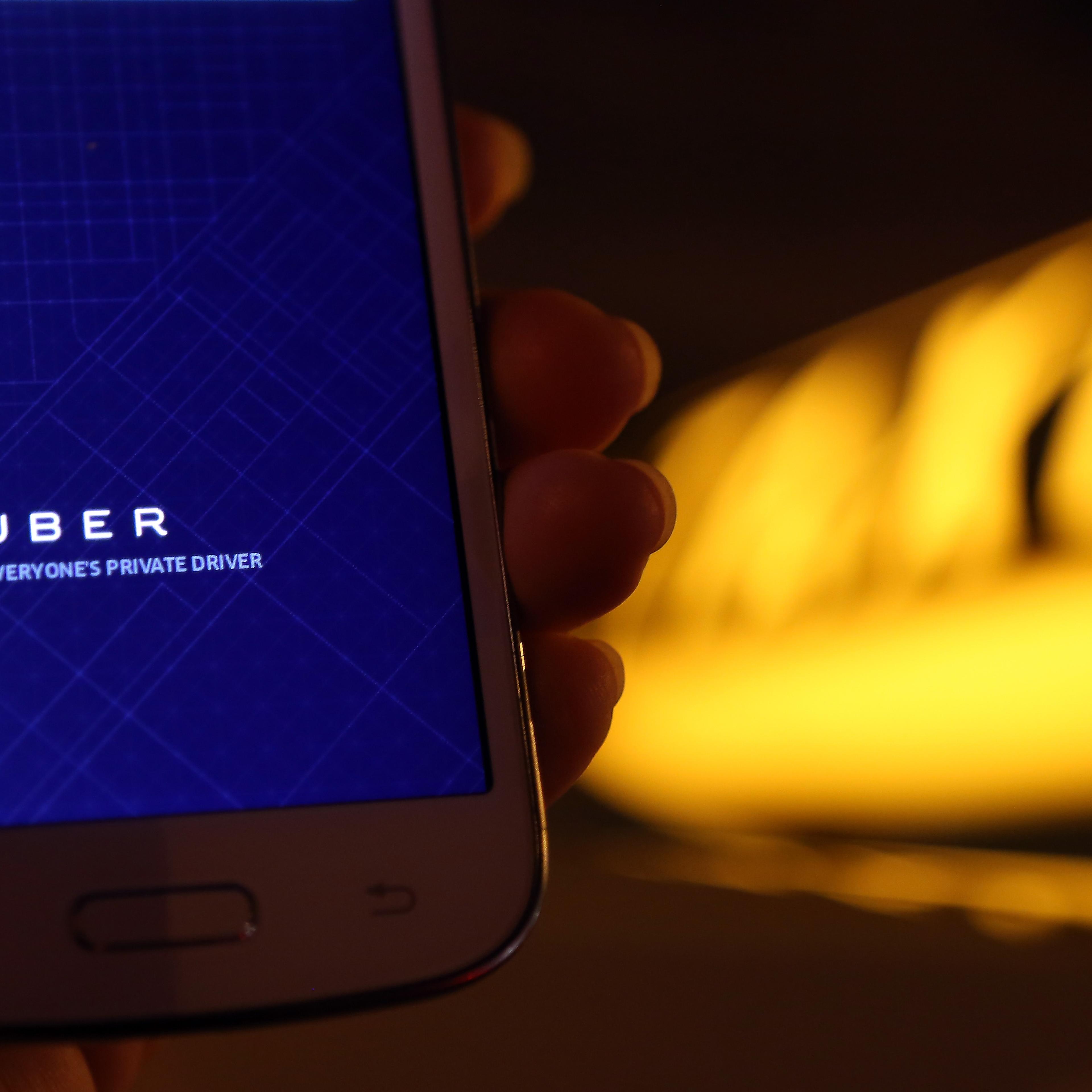 A woman uses the Uber app on an Samsung smartphone on September 2, 2014 in Berlin, Germany.