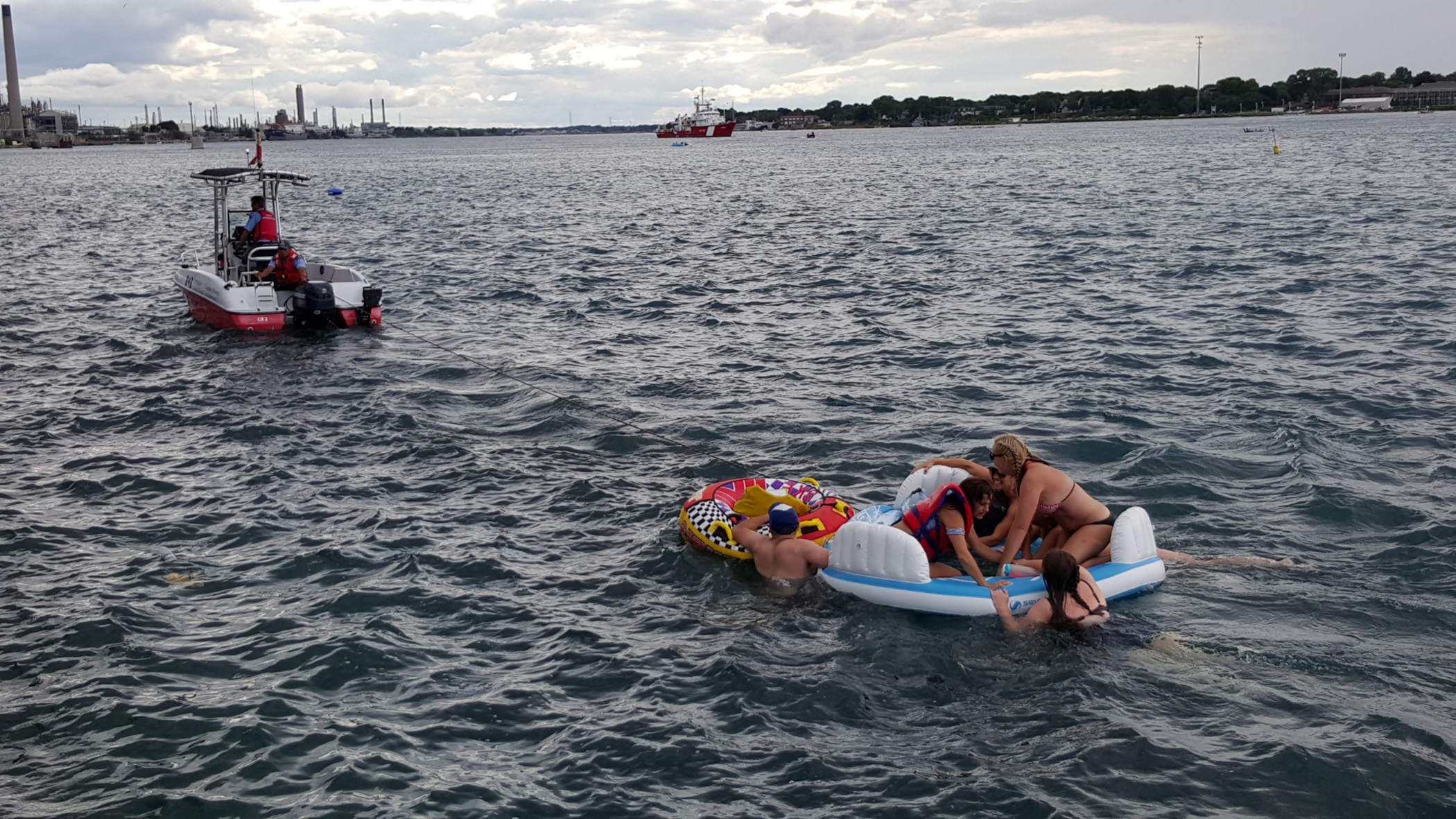 A Canadian Coast Guard ship tows floatation devices used by U.S. partiers to the Canadian side of the St. Clair River between Michigan and Ontario on August 21, 2016. About 1,500 Americans ended up in Canada after getting hit by strong wind and rain. Can