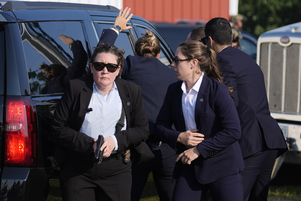 U.S. Secret Service agents surround the vehicle carrying Republican presidential candidate former President Donald Trump at a campaign rally in in Butler, Pa., on July 13, 2024.