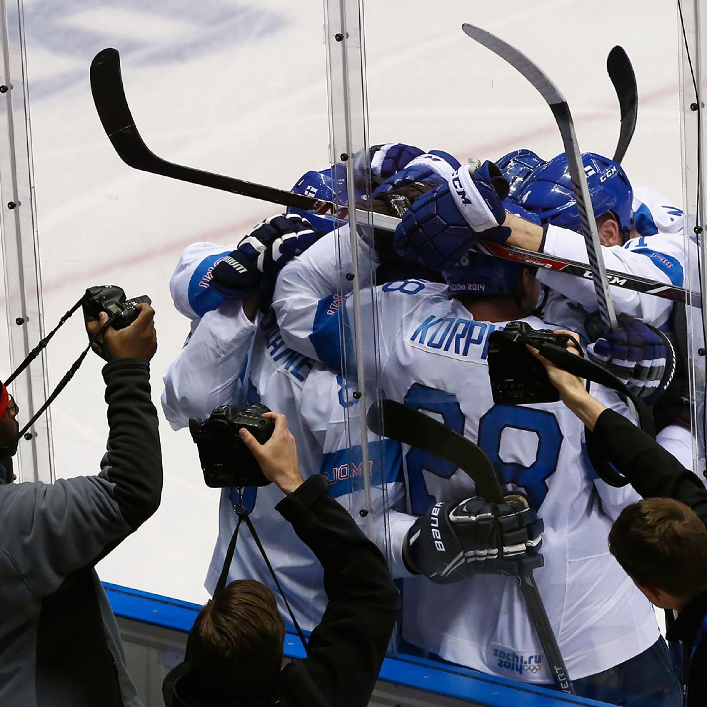 Photographers capture the celebration of Finland's Teemu Selanne and his linemates after he scored against Team USA during the second period of their men's ice hockey bronze medal game.
