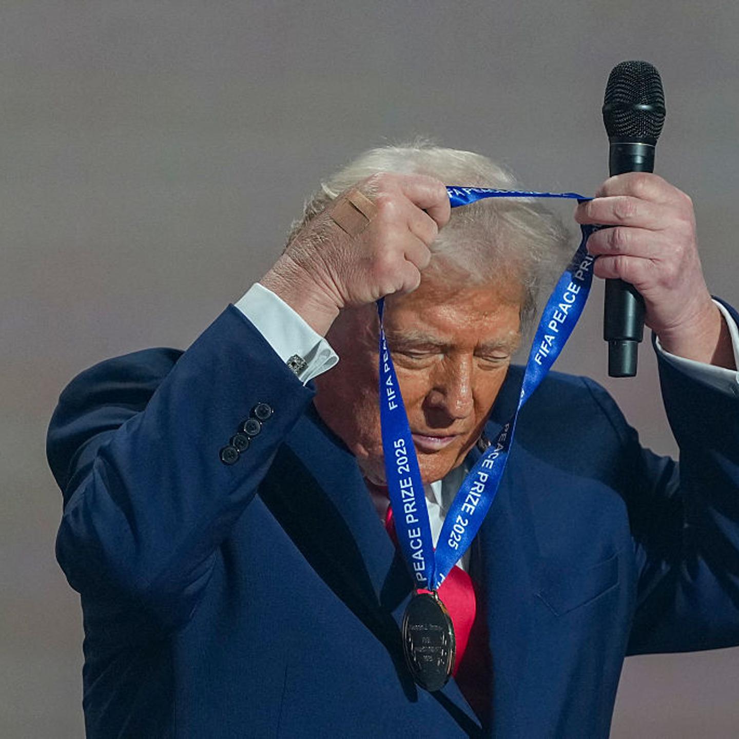 President Donald Trump puts on a medal as he receives the FIFA Peace Prize from FIFA President Gianni Infantino during the draw for the 2026 FIFA Football World Cup at the Kennedy Center, in Washington, D.C., on Dec. 5, 2025.