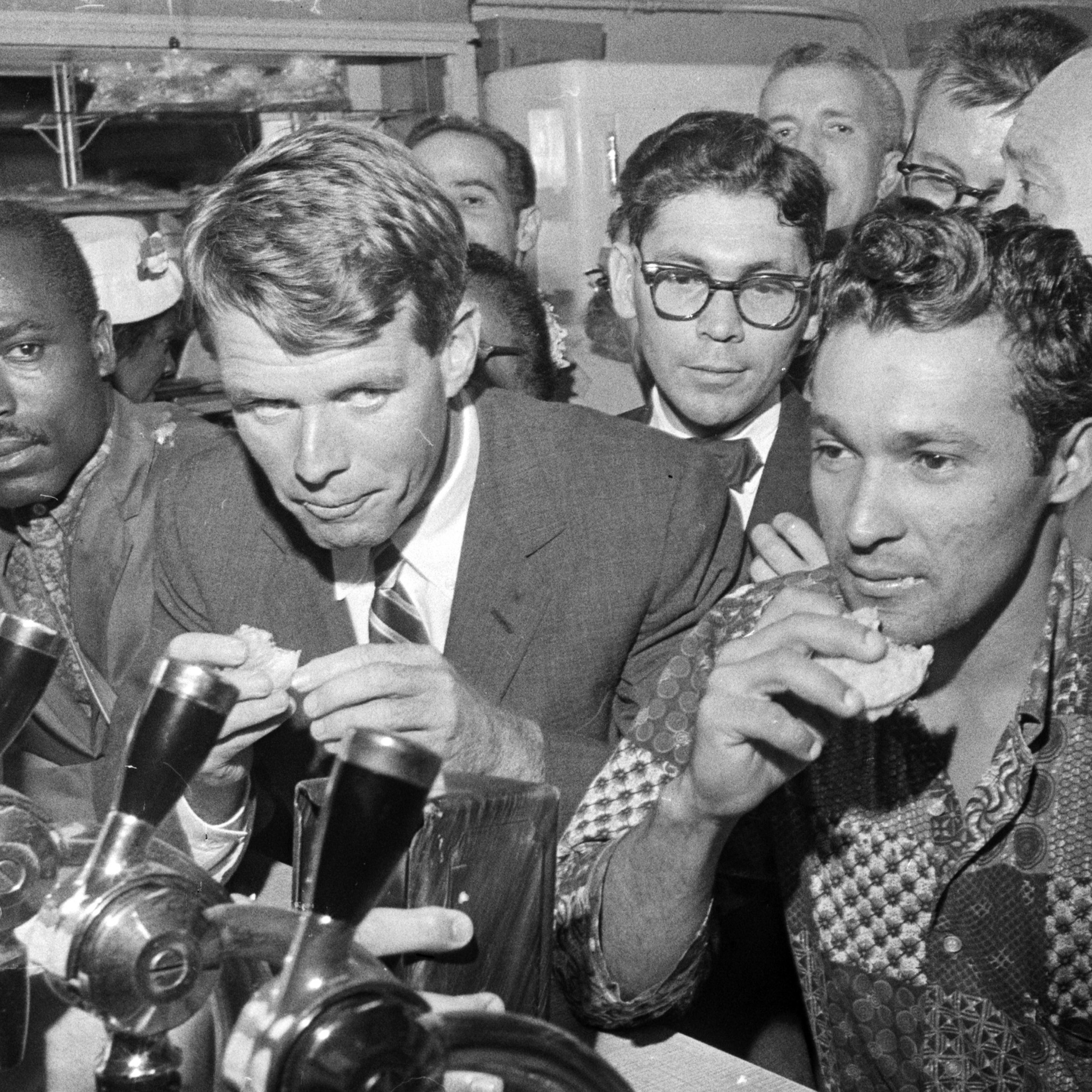 Robert Kennedy, managing his brother's presidential campaign, stops for a snack at a restaurant in Spanish Harlem. August 25, 1960.