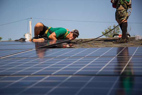Dave Scarantino, senior installer for SolarCity Corp, installs solar panels on the rooftop of a home in Kendall Park, N.J., U.S., on Tuesday, July 28, 2014.