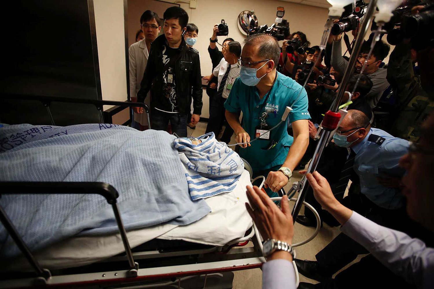 Former Ming Pao chief editor Kevin Lau Chun-to is wheeled into the operation theatre at a hospital in Hong Kong Feb. 26, 2014