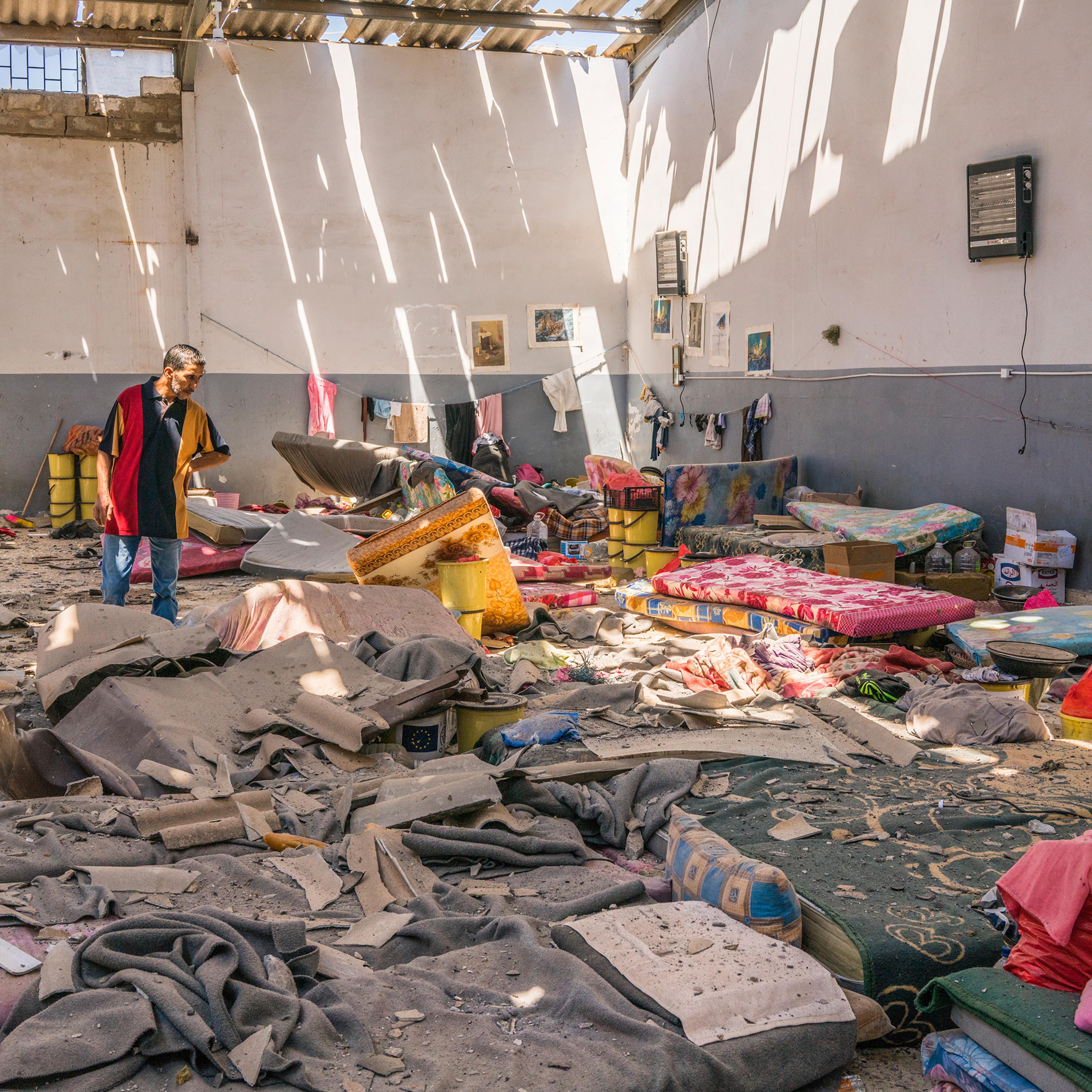 A man inspects damage to an area where migrants slept inside the Tajoura detention center near Tripoli, Libya, on July 3. Dozens of migrants were killed in an attack that was condemned around the world.