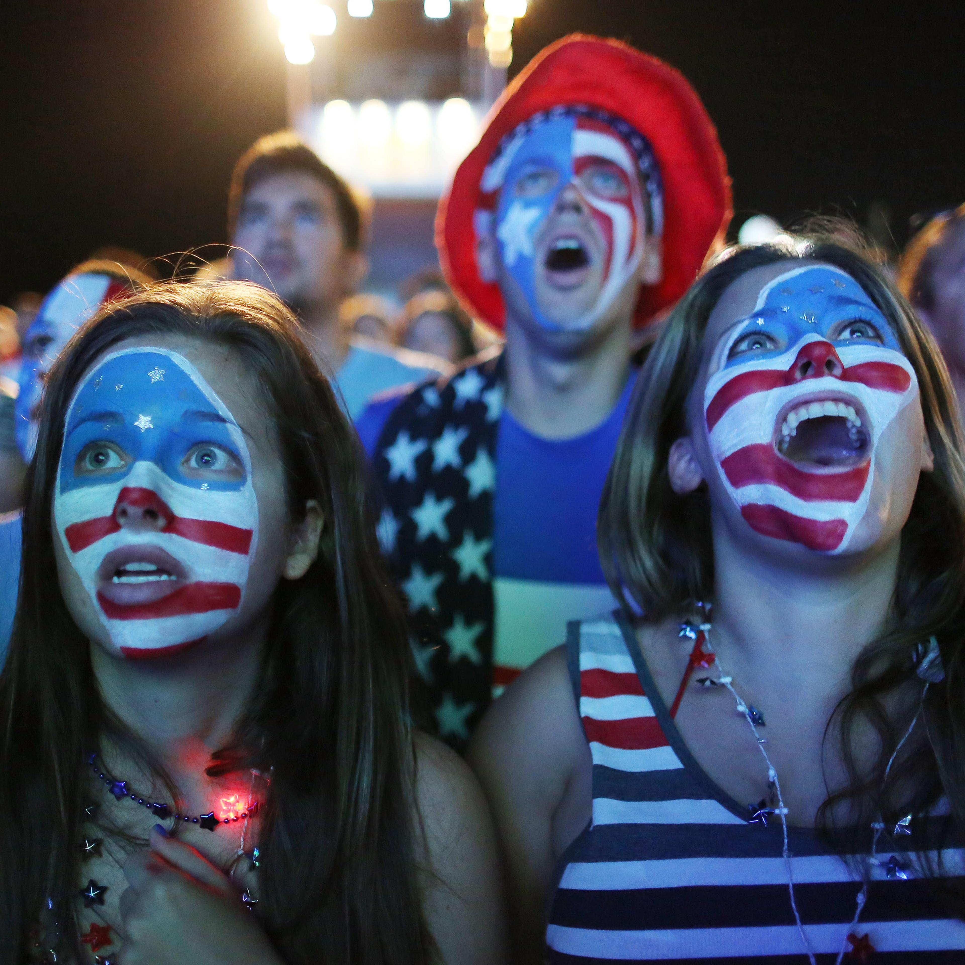 Fans with their faces painted with the U.S. national soccer team's colors, watch a live telecast of the group G World Cup match between United States and Portugal, inside the FIFA Fan Fest area on Copacabana beach, in Rio de Janeiro on June 22, 2014.