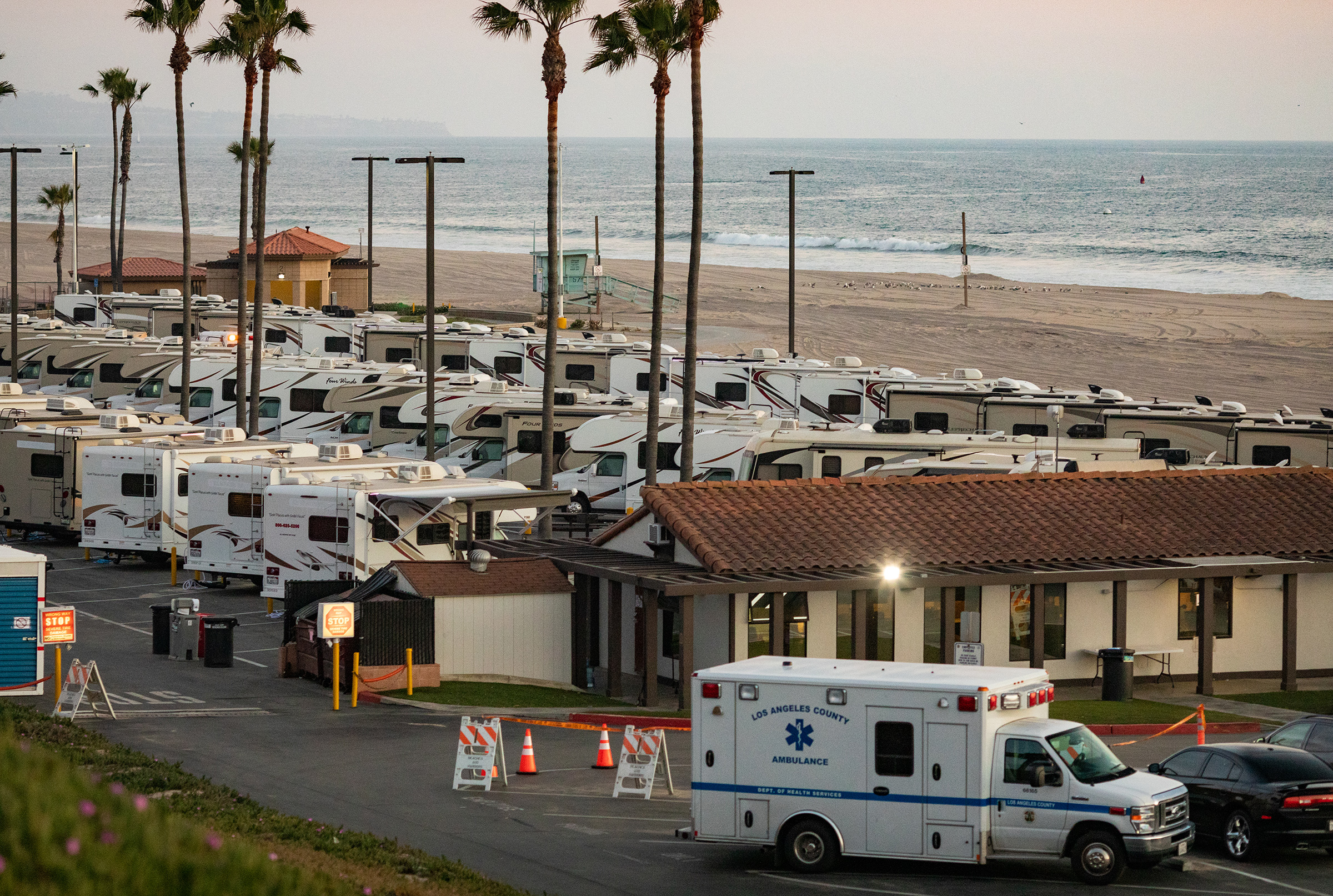 An ambulance arrives in a beachside parking lot being used with R.V's as an isolation zone for people with COVID-19, on April 1st at Dockweiler State Beach in Los Angeles, California