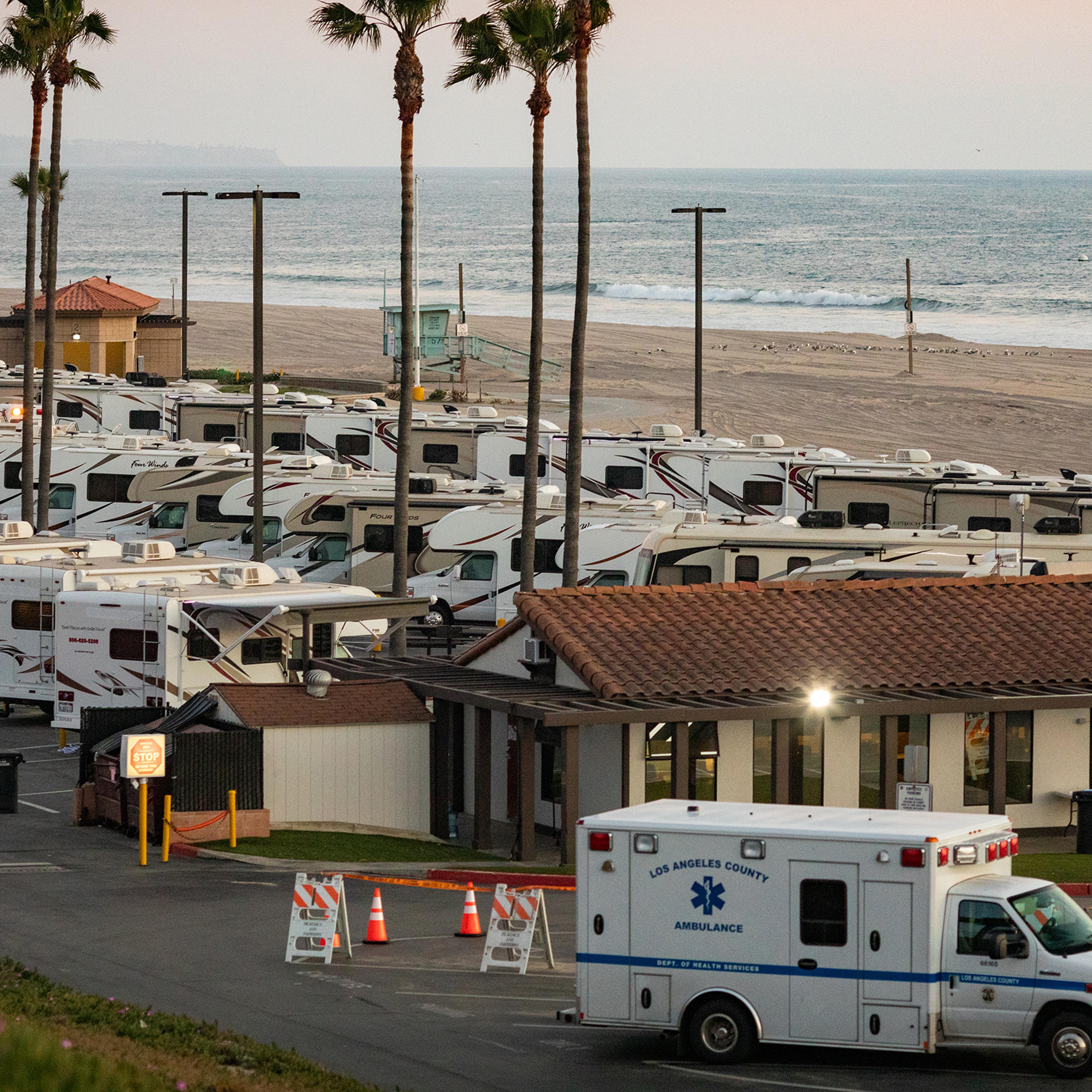 An ambulance arrives in a beachside parking lot being used with R.V's as an isolation zone for people with COVID-19, on April 1st at Dockweiler State Beach in Los Angeles, California
