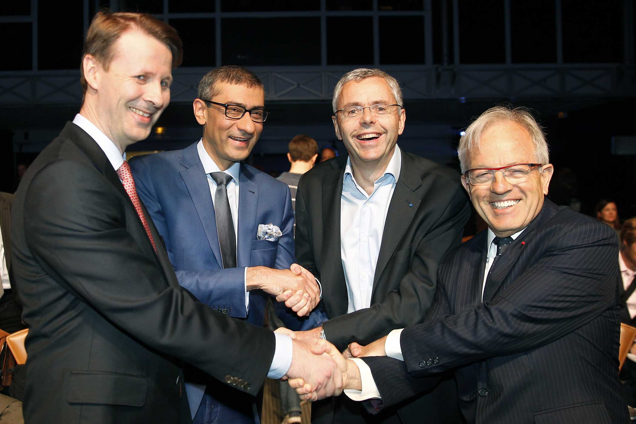 Nokia's chairman Risto Siilasmaa, Nokia's Chief Executive Rajeev Suri, telecommunications company Alcatel-Lucent's Chief Executive Officer Michel Combes and Alcatel-Lucent's chairman of the supervisory board Philippe Camus shake hands prior a press confe