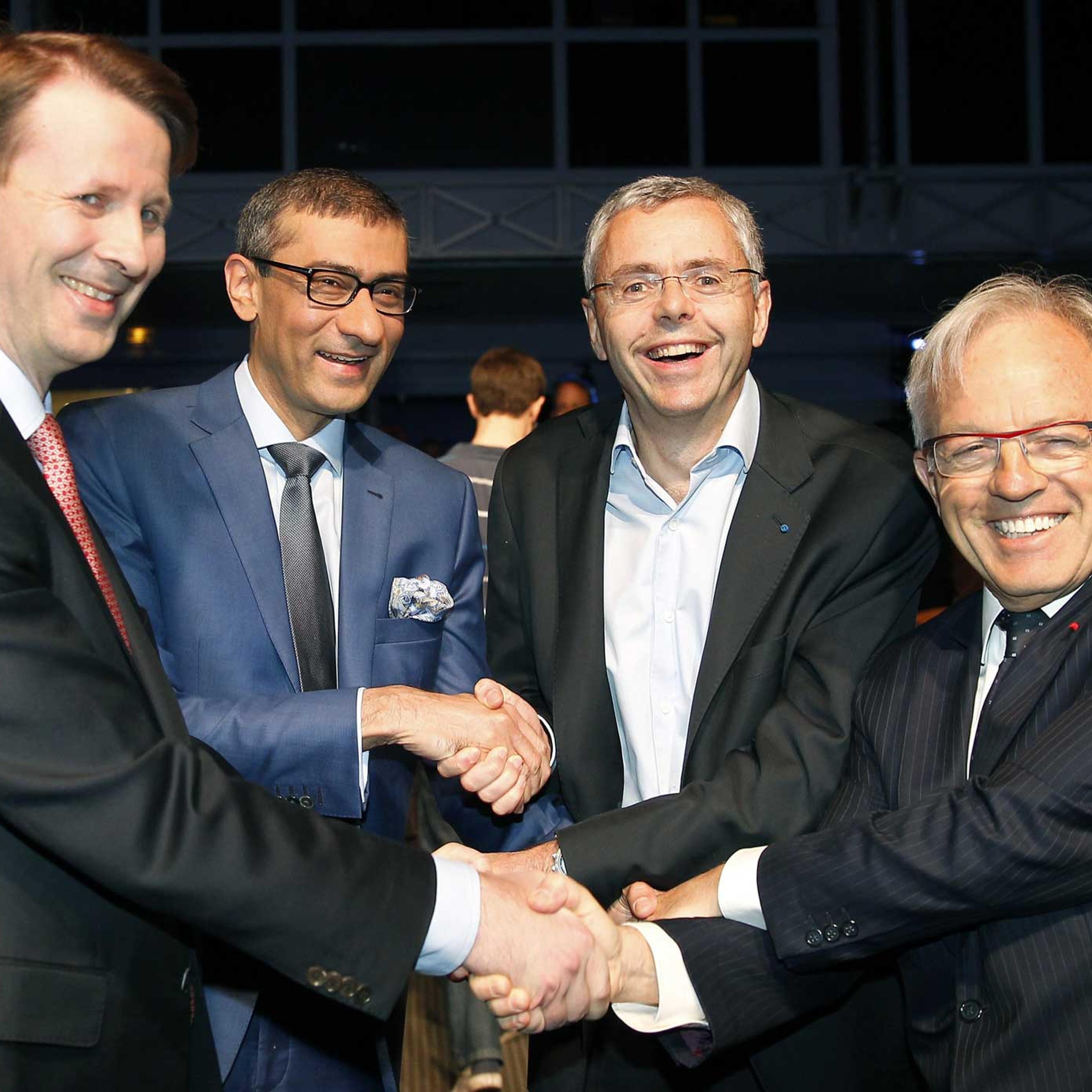 Nokia's chairman Risto Siilasmaa, Nokia's Chief Executive Rajeev Suri, telecommunications company Alcatel-Lucent's Chief Executive Officer Michel Combes and Alcatel-Lucent's chairman of the supervisory board Philippe Camus shake hands prior a press confe