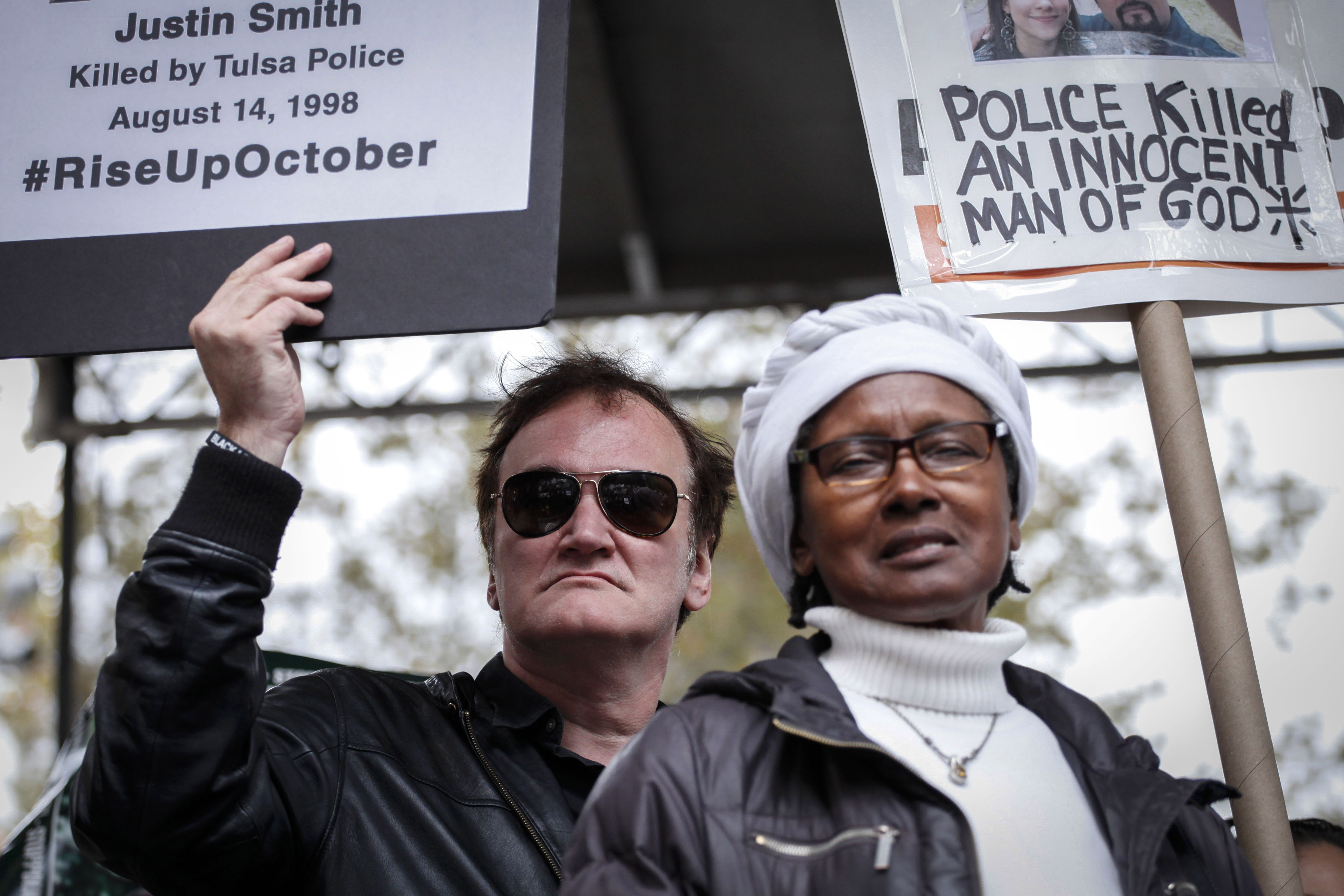 Director Quentin Tarantino holds a banner as attends a rally to denounce police brutality in New York City on Oct.r 24, 2015.
