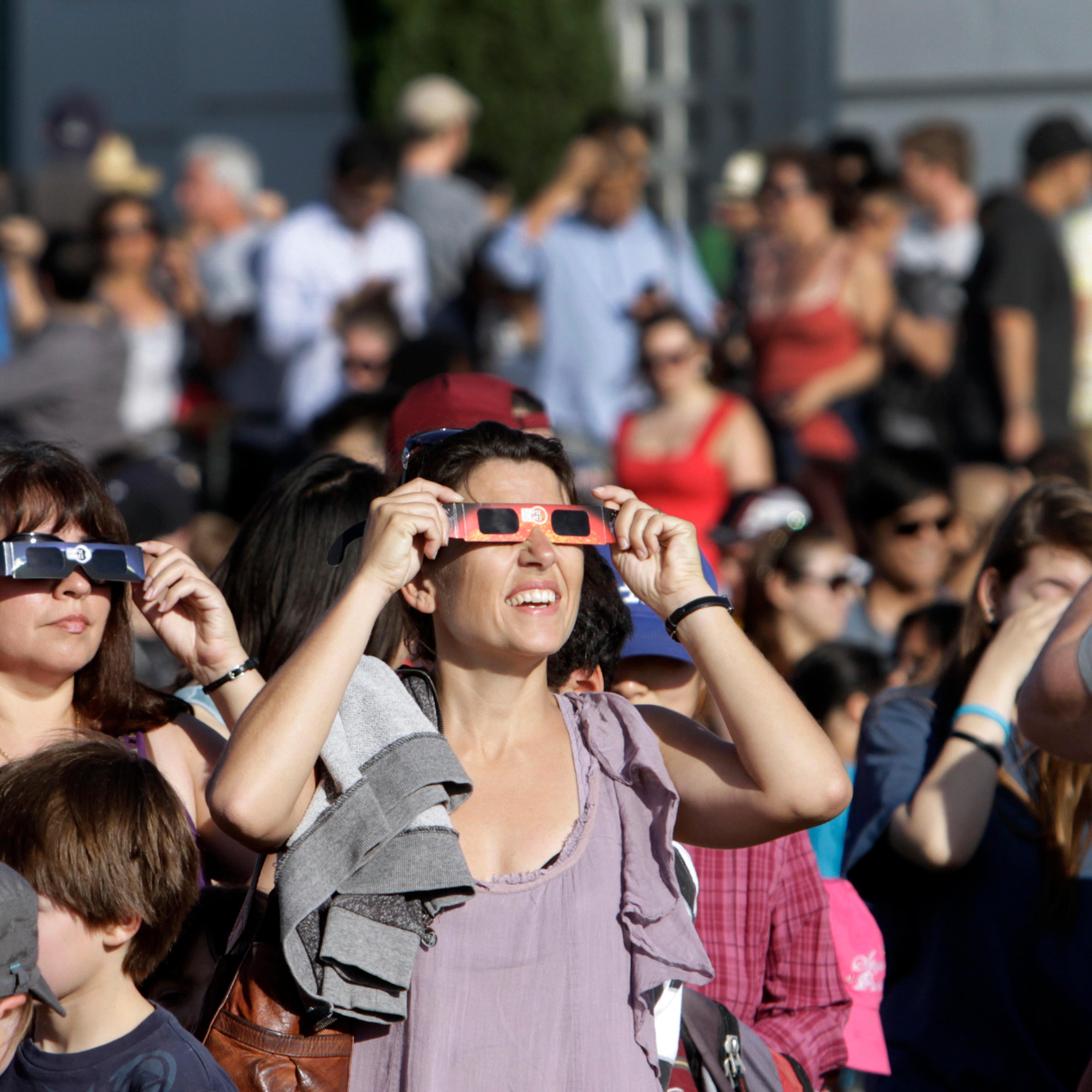 Visitors at the park. Griffith observatory in Los Angeles holds a public viewing of the partial sol