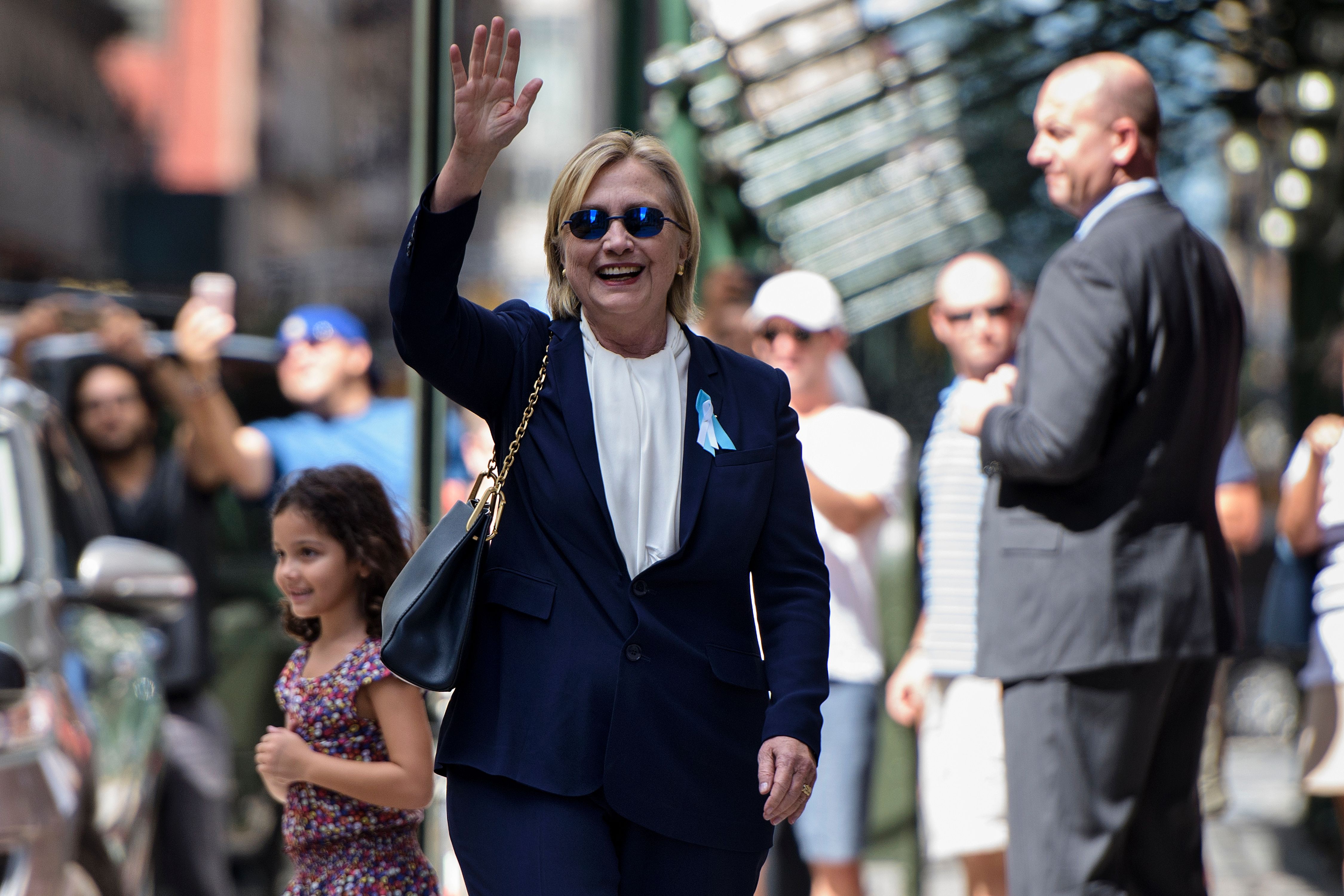 Democratic presidential nominee Hillary Clinton waves to the press as she leaves her daughter's apartment building after resting in New York on on Sept. 11, 2016.