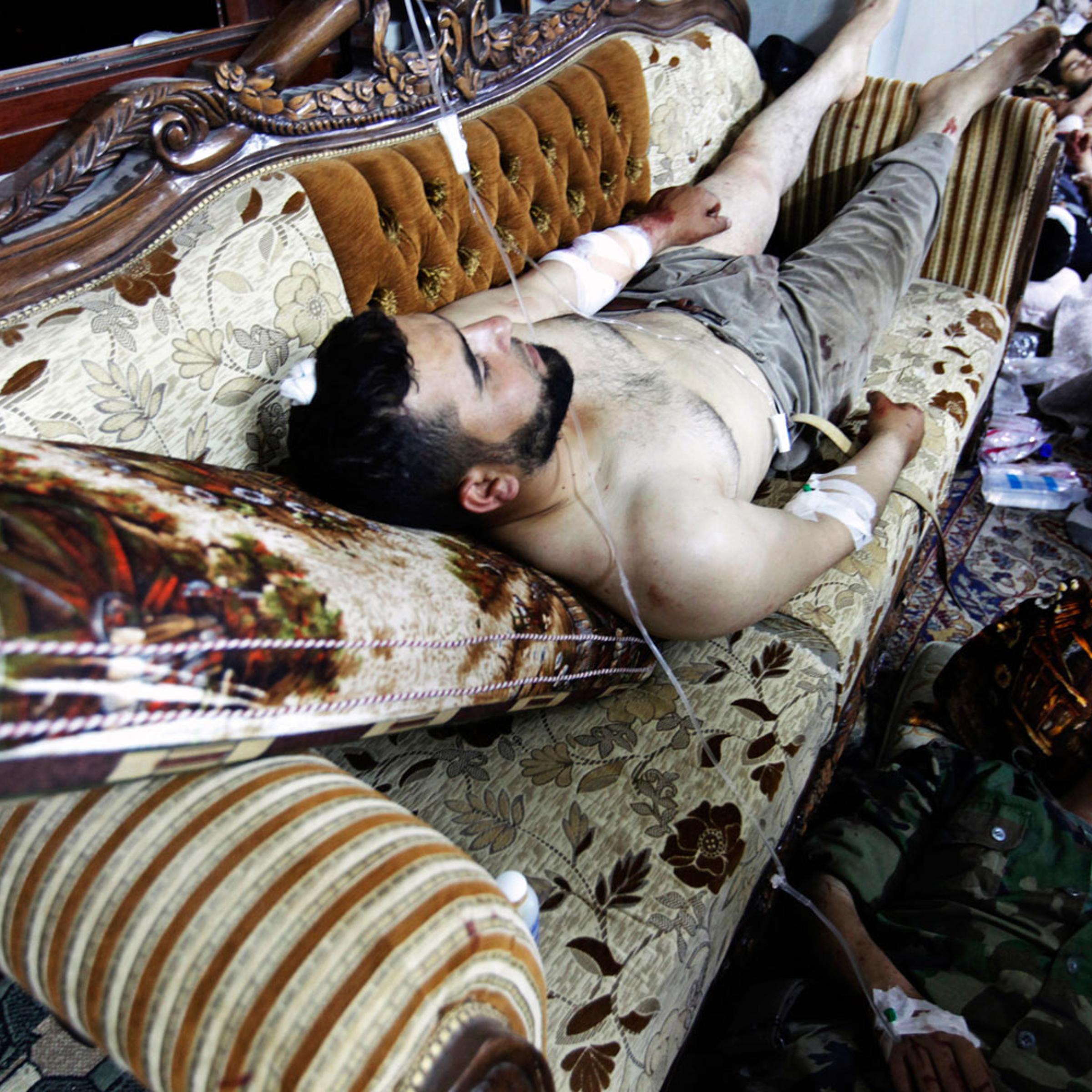 Medical volunteers treat wounded Free Syrian Army soldiers inside a home after the field hospital reached capacity