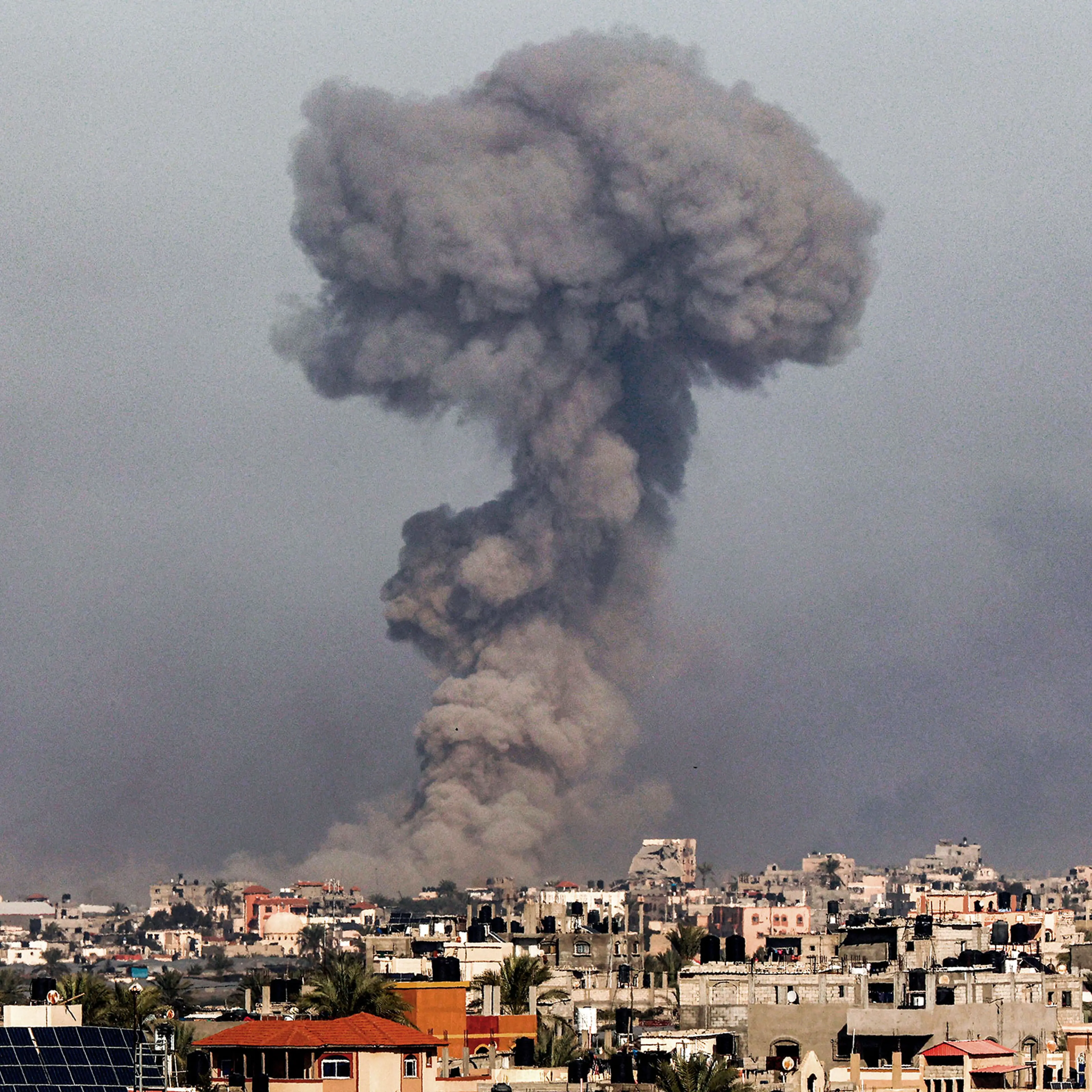 A smoke plume erupts over Khan Yunis from Rafah in the southern Gaza strip during Israeli bombardment on Jan. 8, 2024.