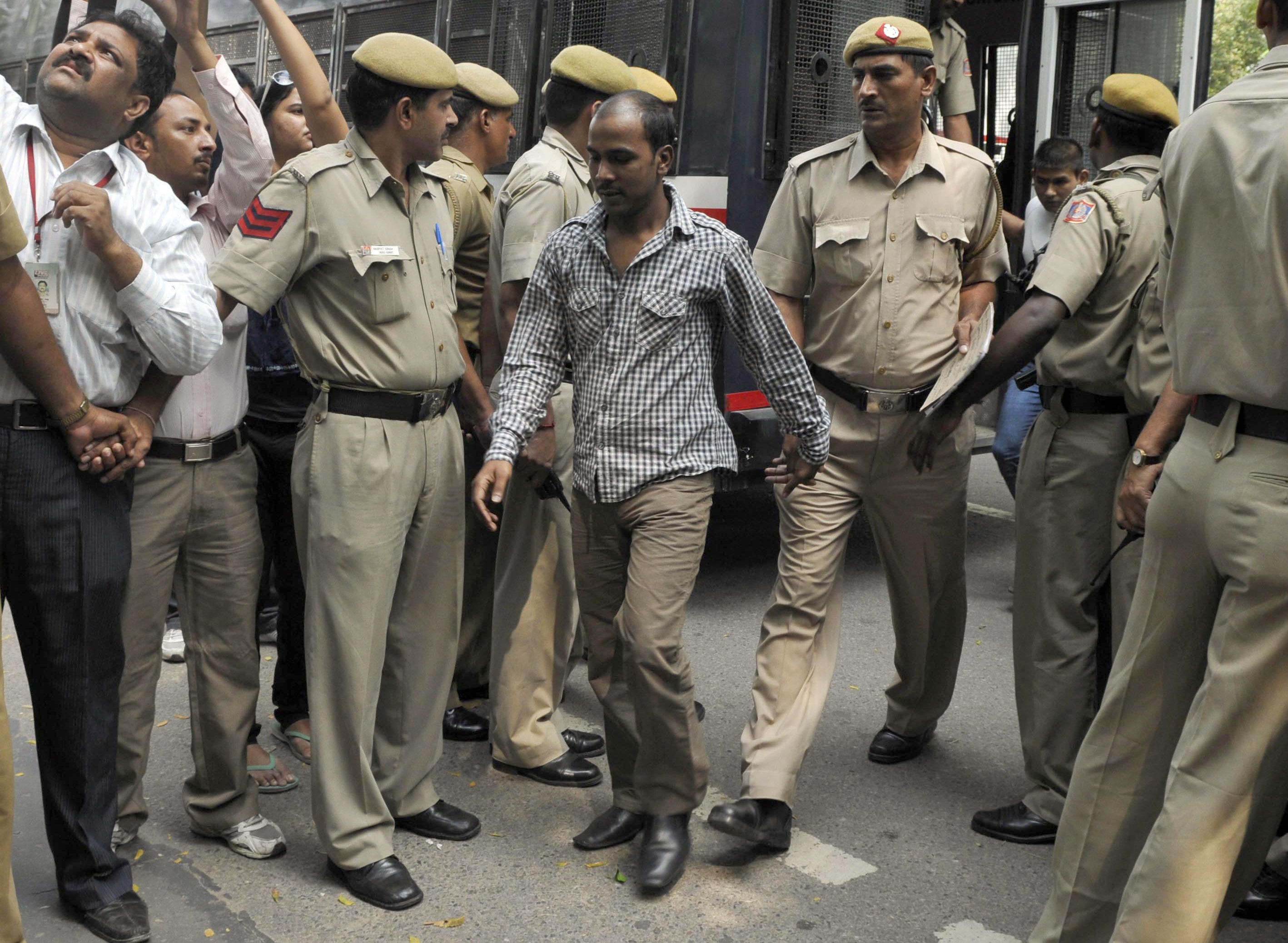 Mukesh Singh, one of the four men who were sentenced to death for the rape and murder of a young woman on a bus last December, is escorted by police outside a court in New Delhi