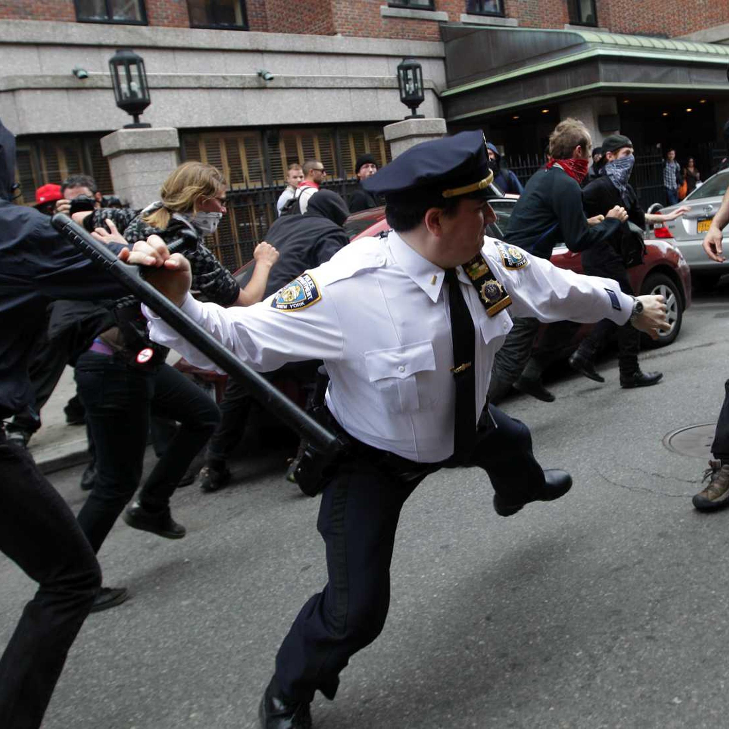 A police lieutenant swings his baton at Occupy Wall Street activists in New York City on May 1, 2012.