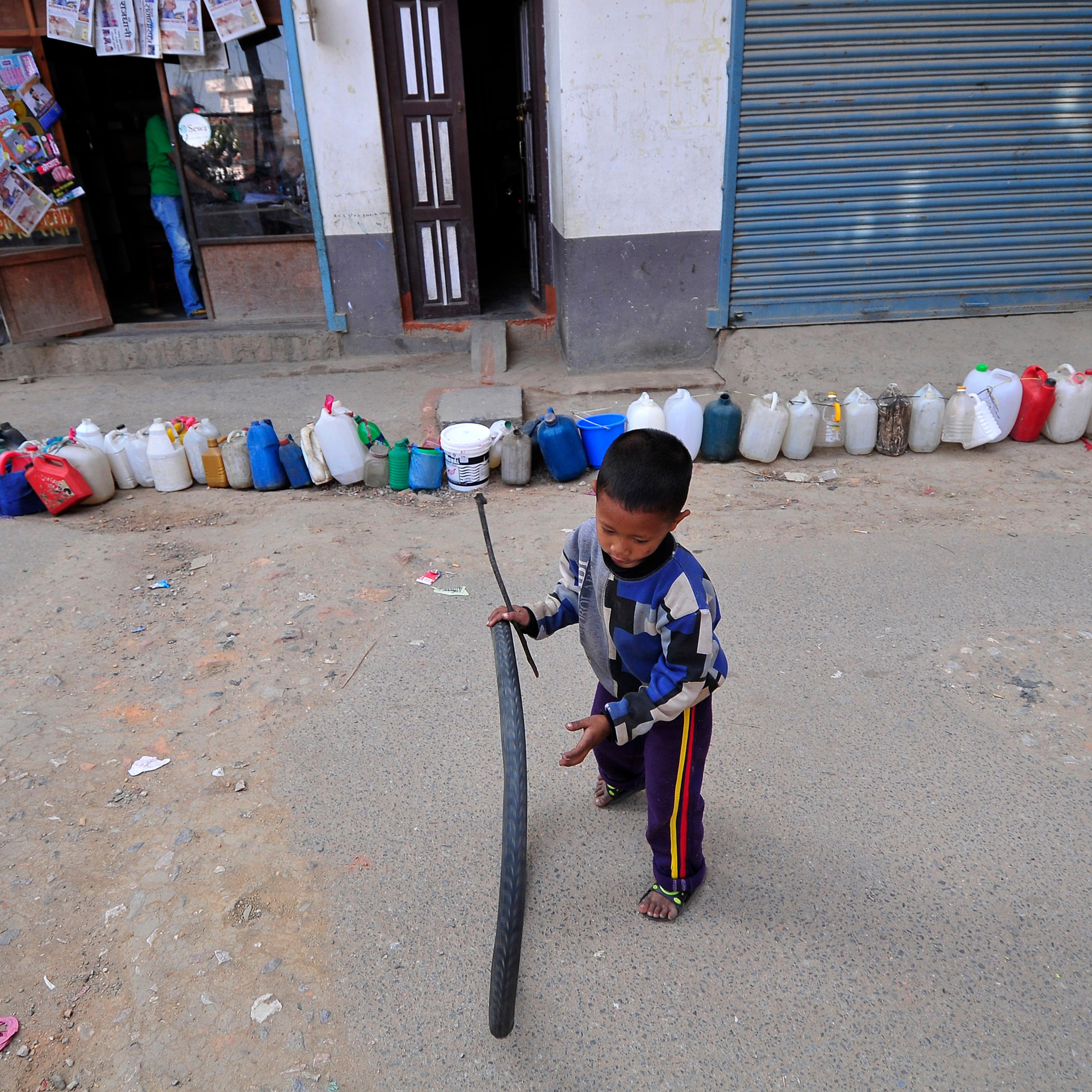 A Nepalese kid plays while waiting for his parents' time to