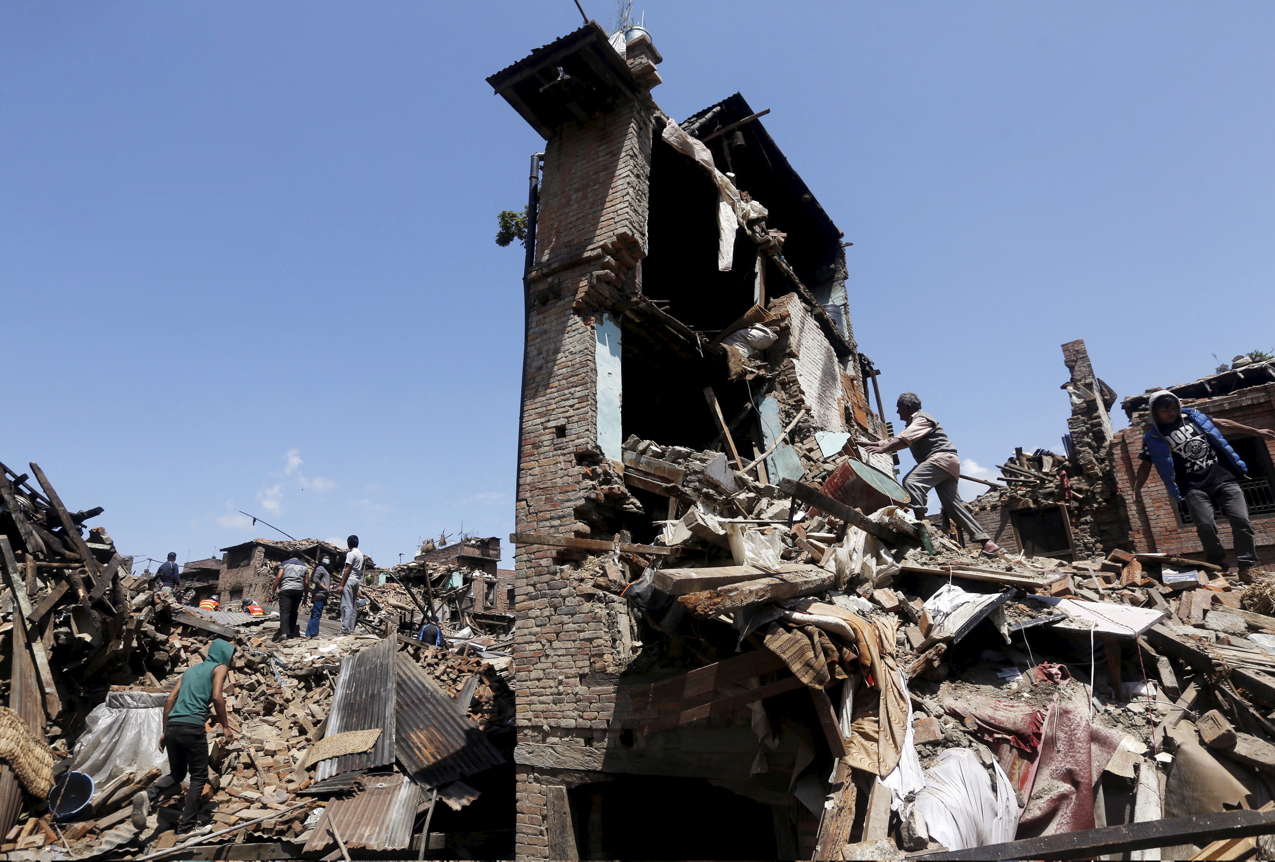 Man looks into his damaged house to recover belongings following Saturday's earthquake in Bhaktapur, Nepal