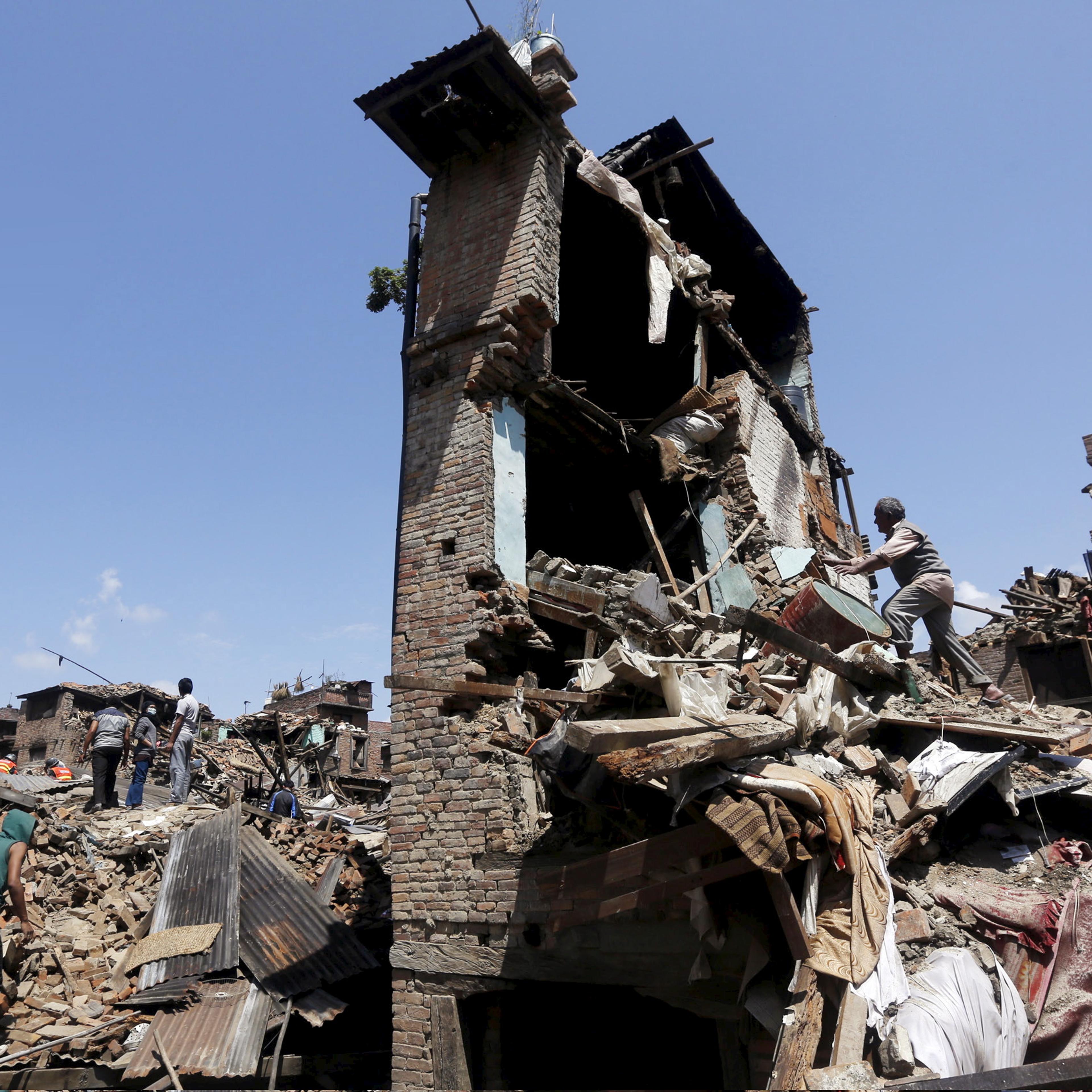 Man looks into his damaged house to recover belongings following Saturday's earthquake in Bhaktapur, Nepal