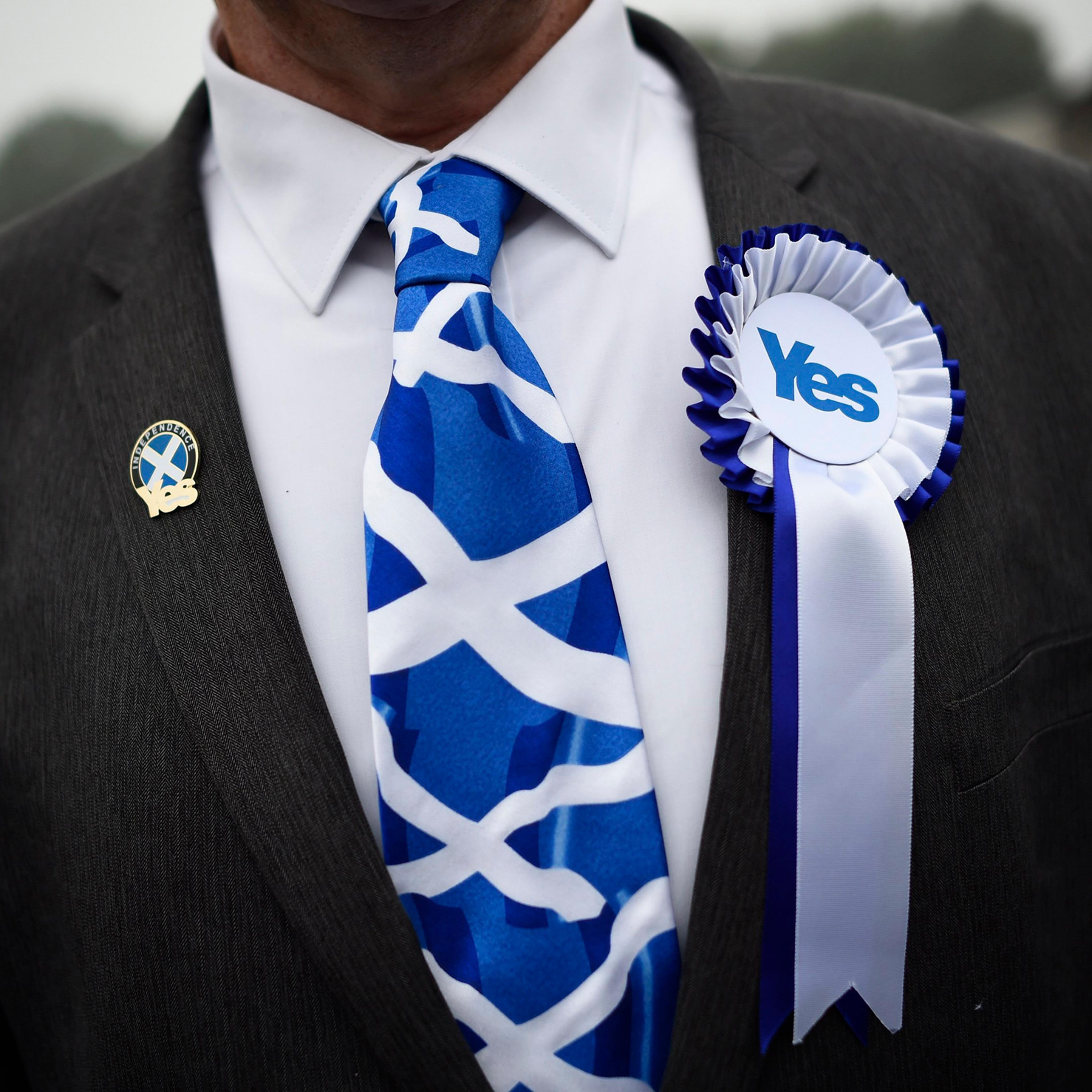 A supporter of the 'Yes' campaign stands outside a polling station as Scotland's First Minister Alex Salmond casts his vote during the referendum on Scottish independence in Strichen, Scotland, Sept. 18, 2014.