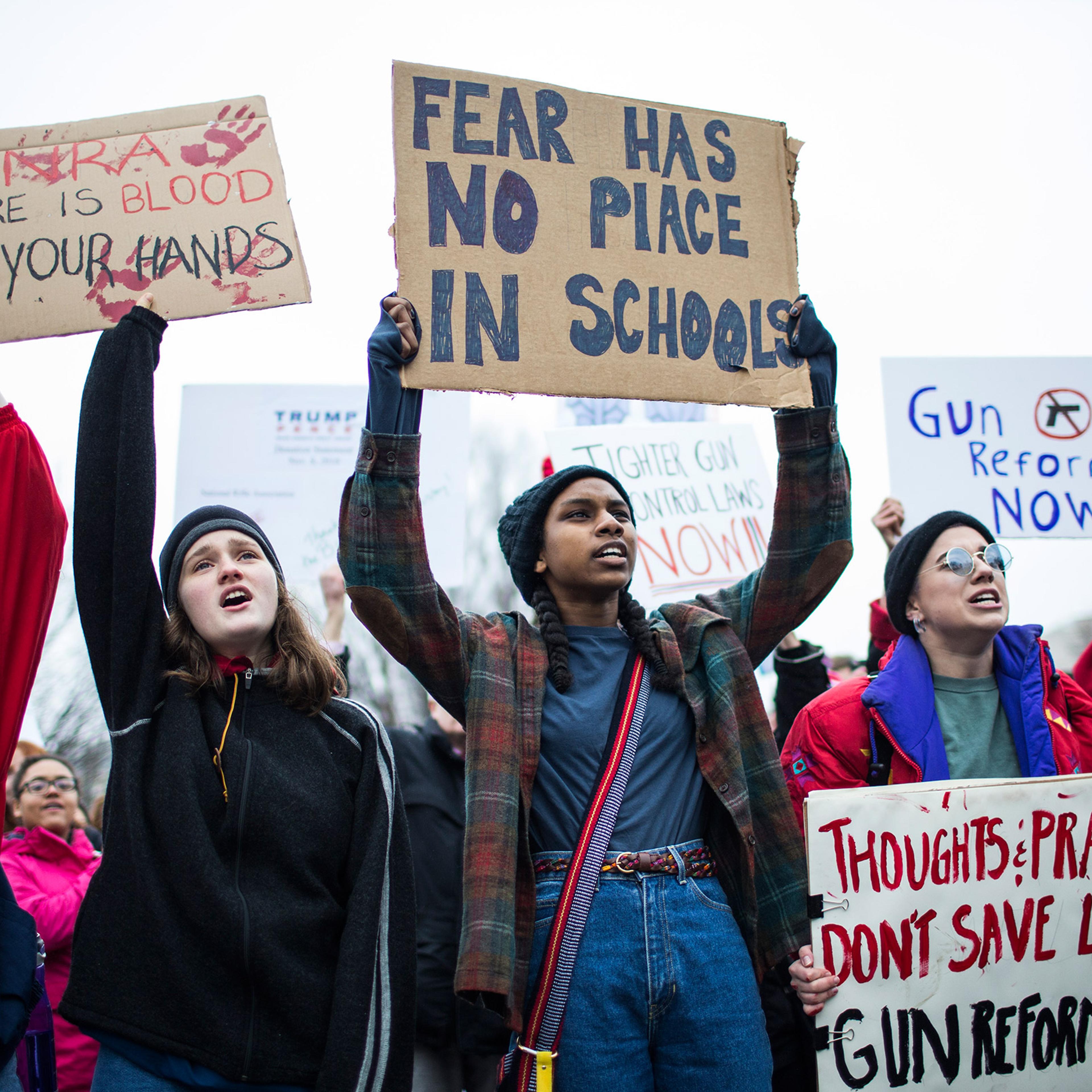 Demonstrators hold signs during a demonstration supporting gun-control reform near the White House on Feb. 19, 2018, in Washington, D.C.