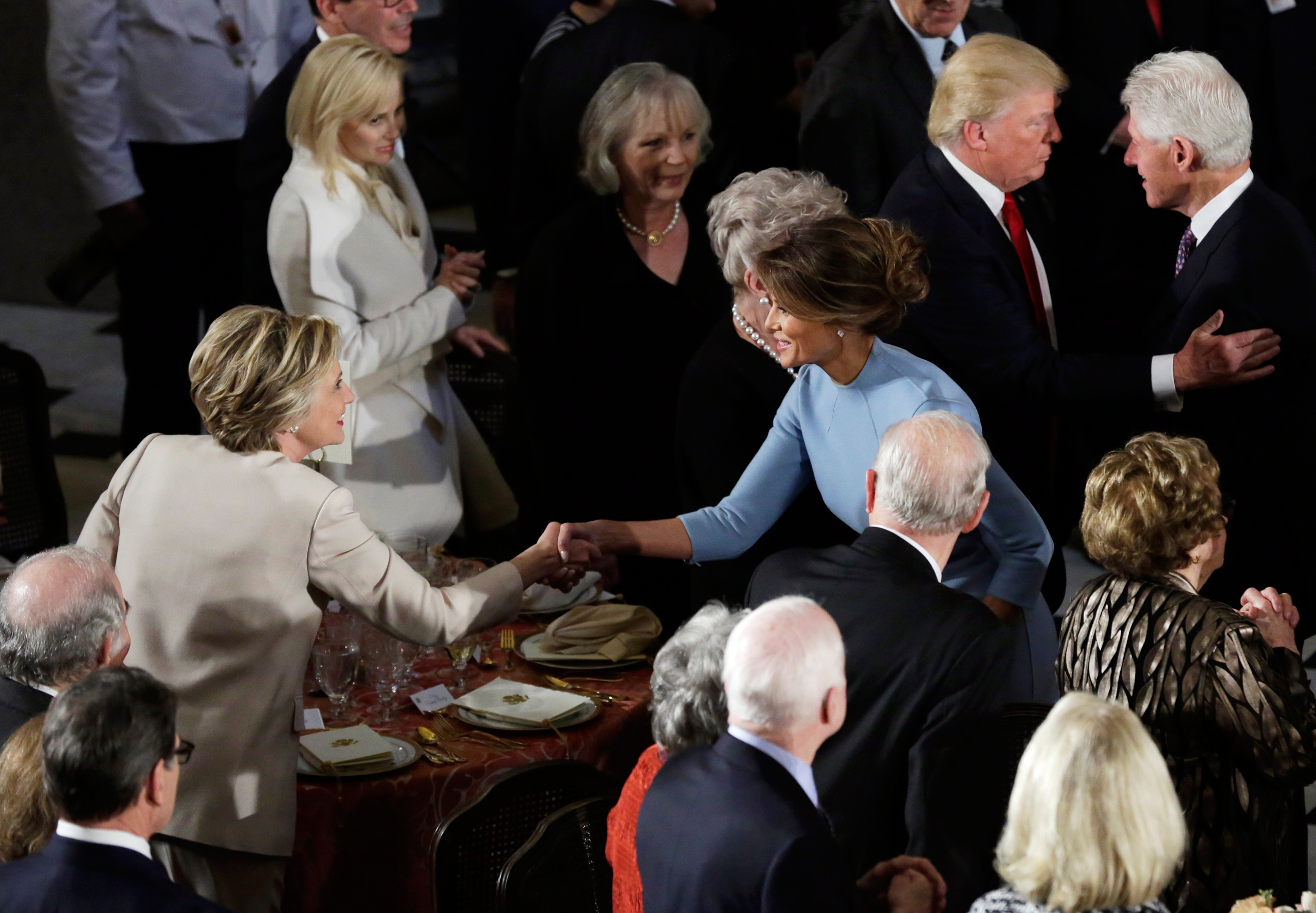 Former Democratic U.S. presidential nominee Hillary Clinton greets First lady Melania Trump as her husband Bill Clinton speaks with President Donald Trump during the Inaugural luncheon at the National Statuary Hall in Washington, U.S, January 20, 2017. R