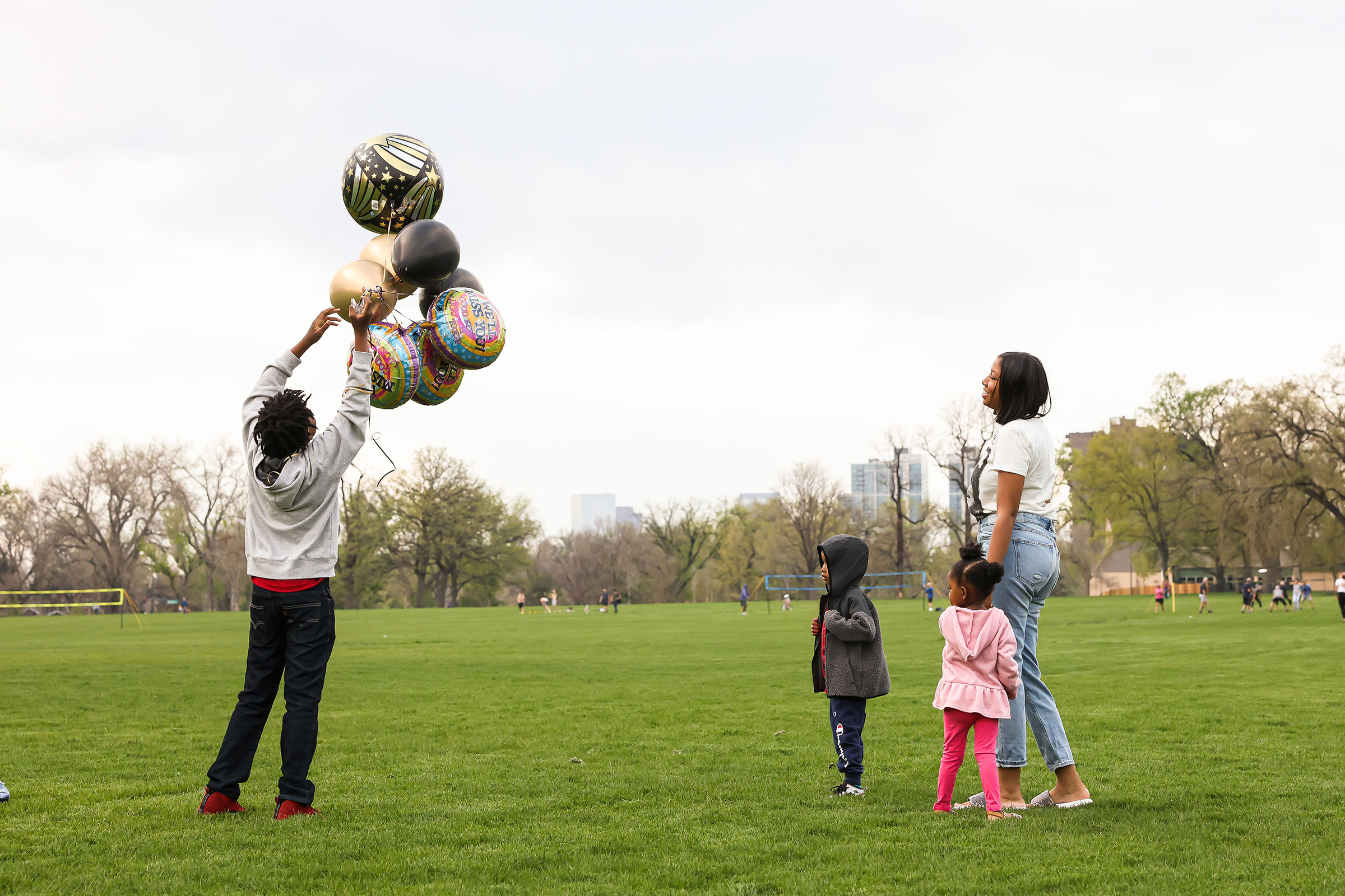 Nehemiah prepares to release balloons in commemoration of the death of his father while his mother Ashley, his 4-year-old bother, Prince, and 3-year-old sister, Zyla, watch nearby
