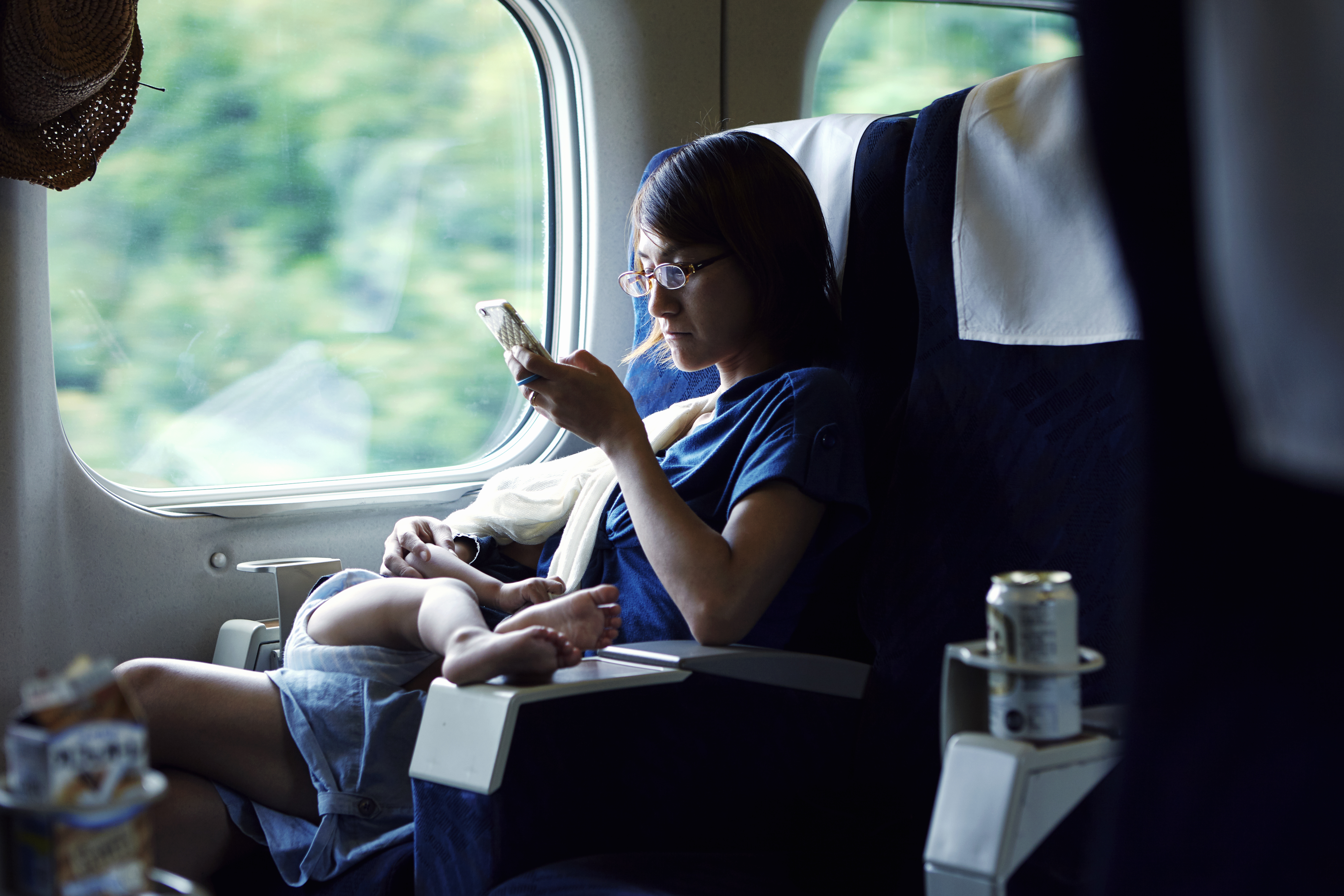 Mother using smartphone while breastfeeding on train