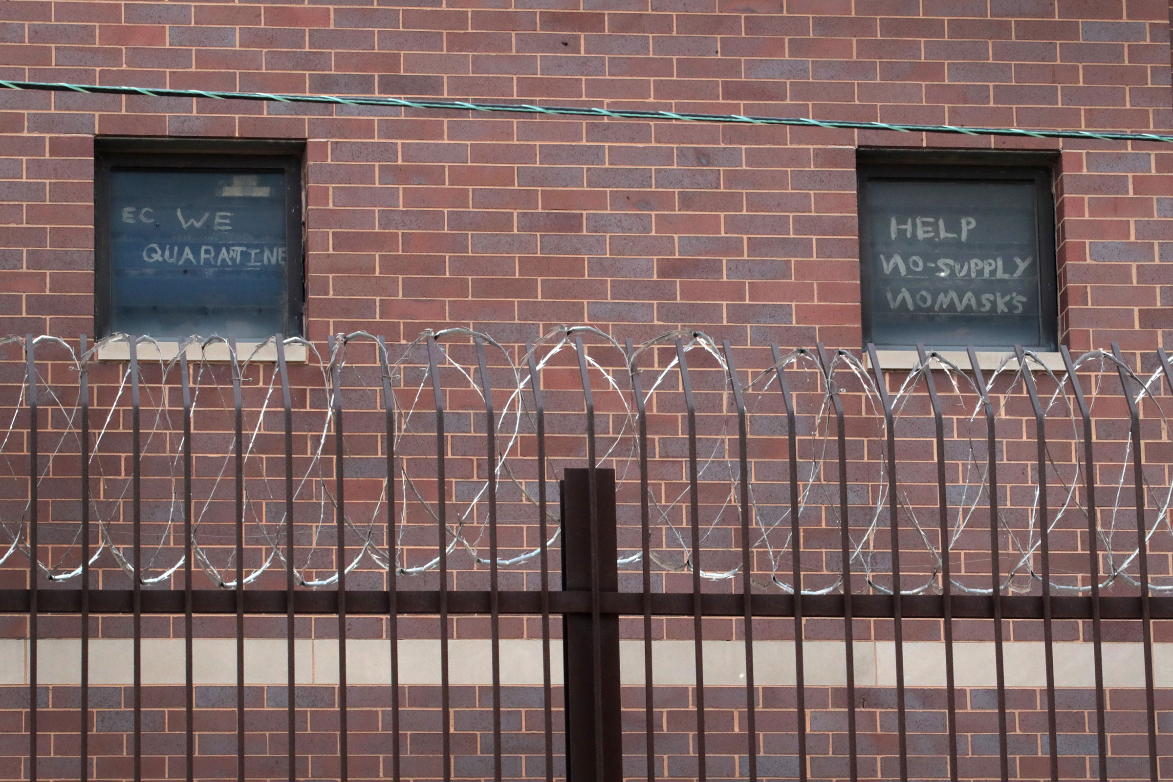 Signs pleading for help hang in windows at the Cook County jail complex