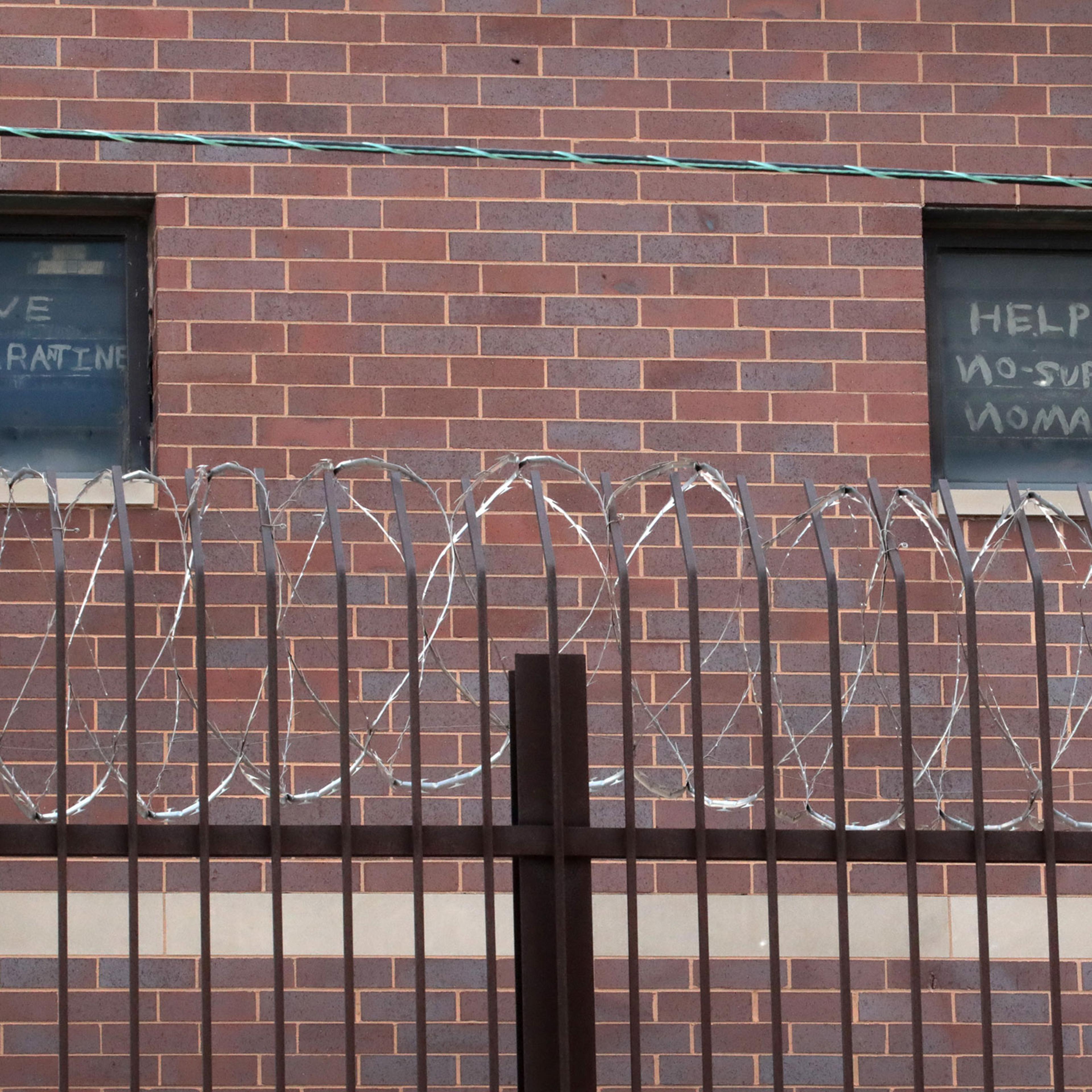 Signs pleading for help hang in windows at the Cook County jail complex